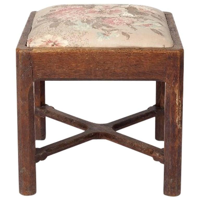 Gordon Russell. An Arts & Crafts Cotswold School oak stool with carved sculptured cross stretcher with pegged joints.