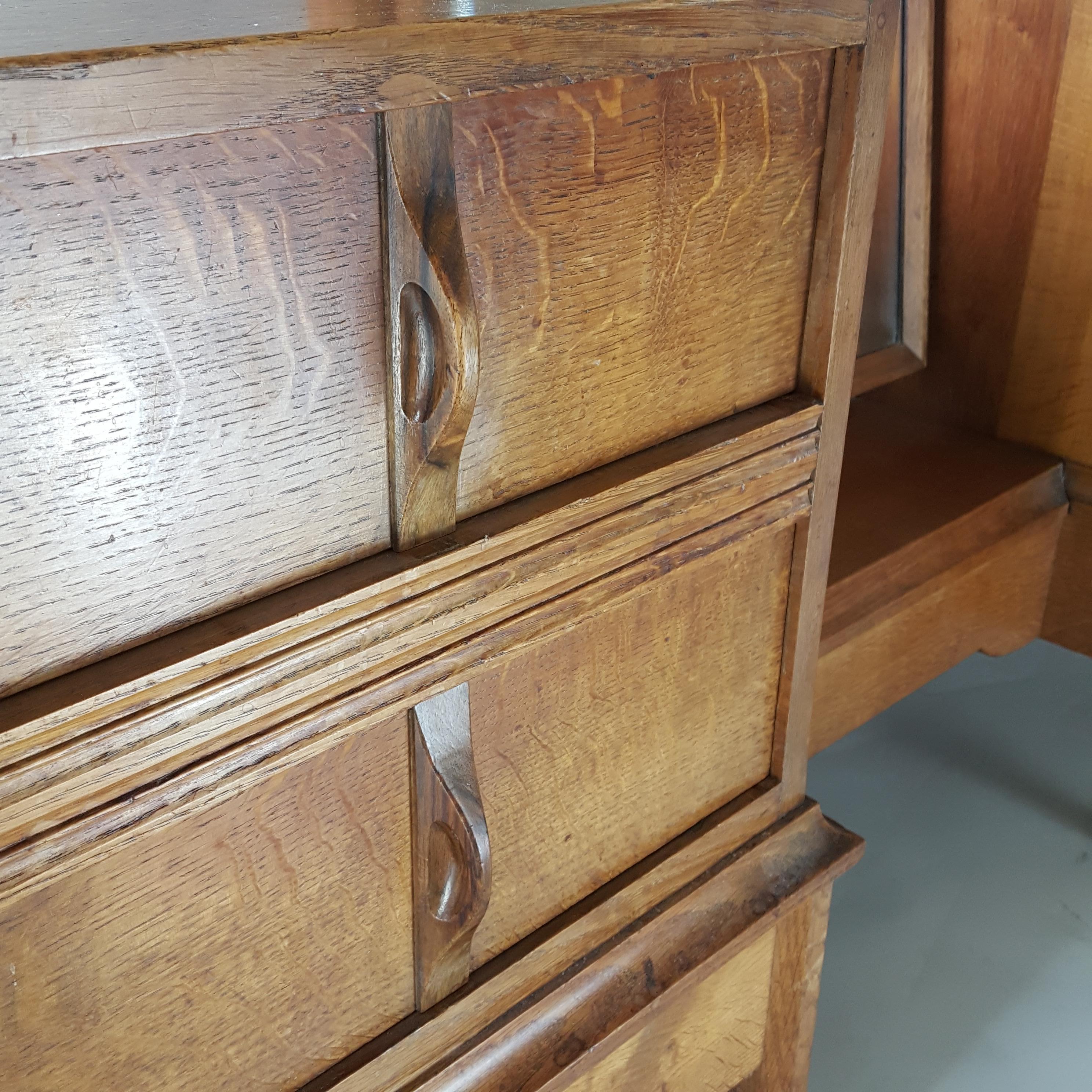 Sir Gordon Russell, (British, 1892-1980). An oak Arts & Crafts Cotswolds School oak dressing table. The dressing table has a swivel central bevelled mirror with quality hand crafted brass tighteners and hand carved Walnut handles. 
The dressing