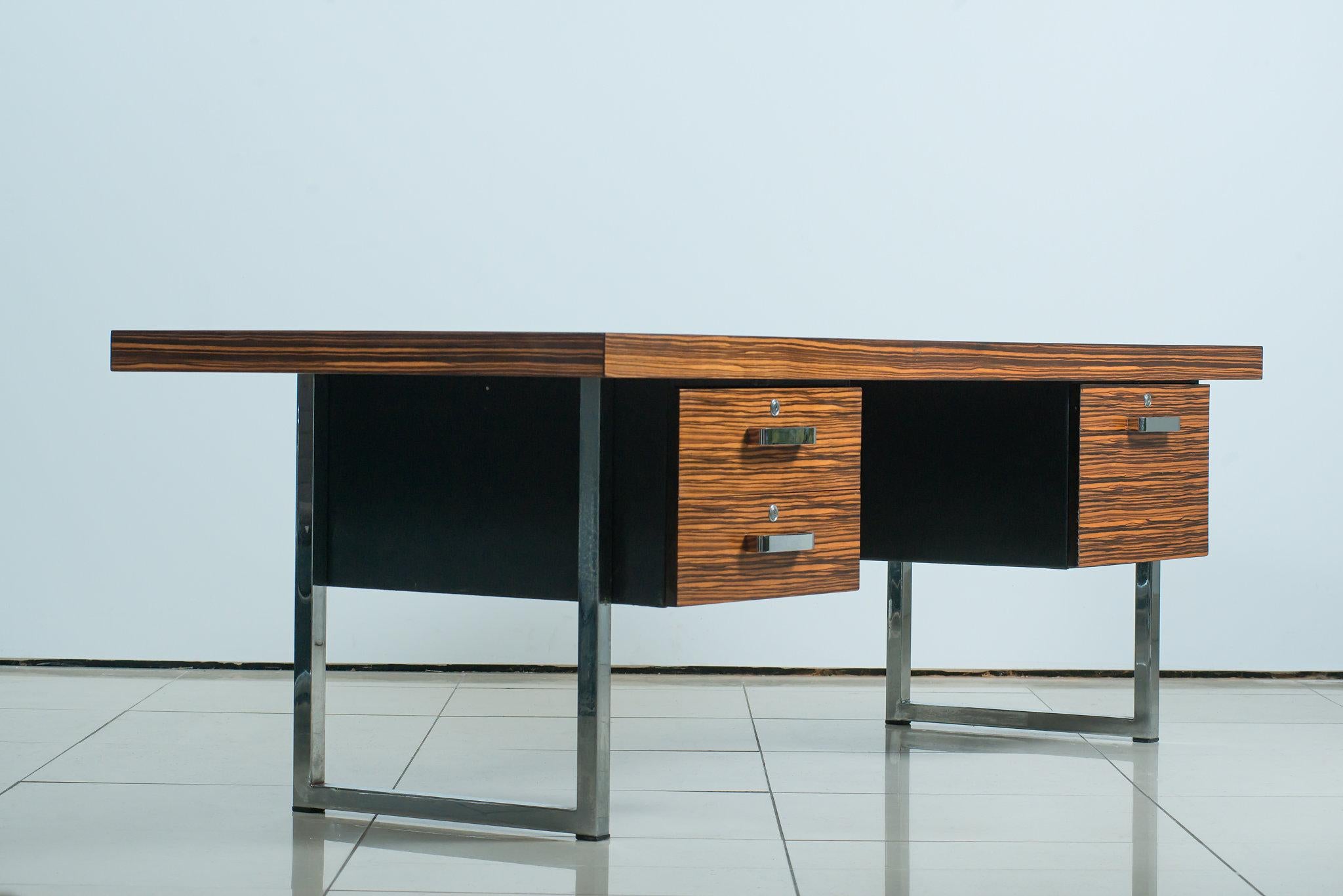 A Gordon Russel executive desk designed by Trevor Chinn in ebony macassar wood with chrome steel legs. A very unusual and rare piece by one of the great names in English 20th century furniture. Extraordinary marking to the grain.

 