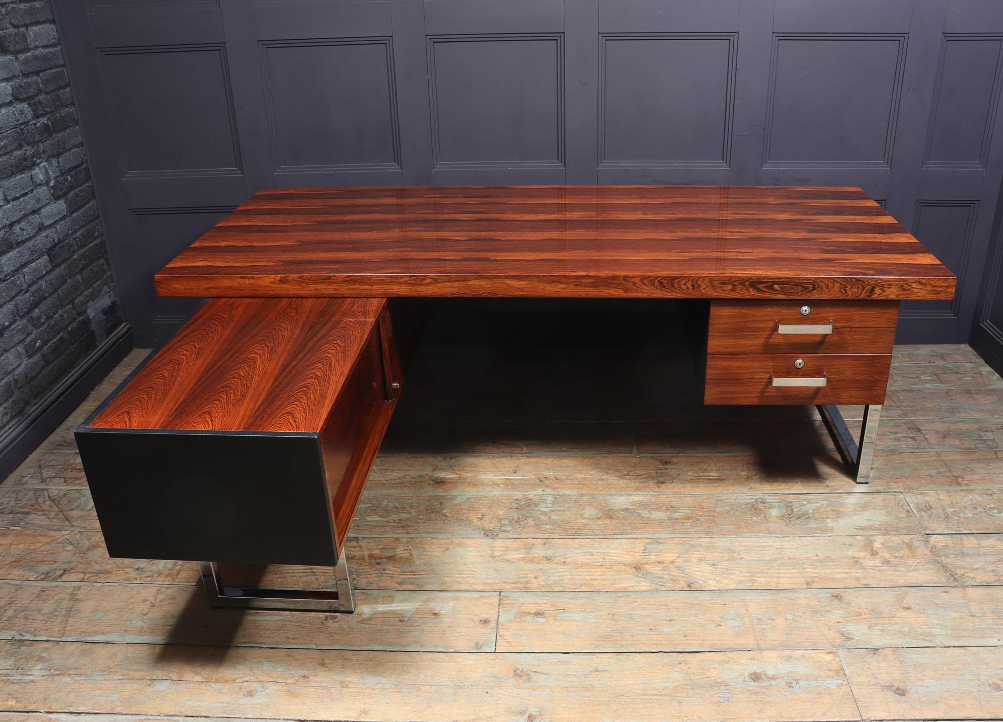 A vintage Mid-Century Modern desk from the prestige range by Gordon Russell, designed by Trevor Chinn in the 1970’s, this L-Shaped desk in rosewood with chrome metalwork and vinyl backing is in extremely good condition and lovely graining to the