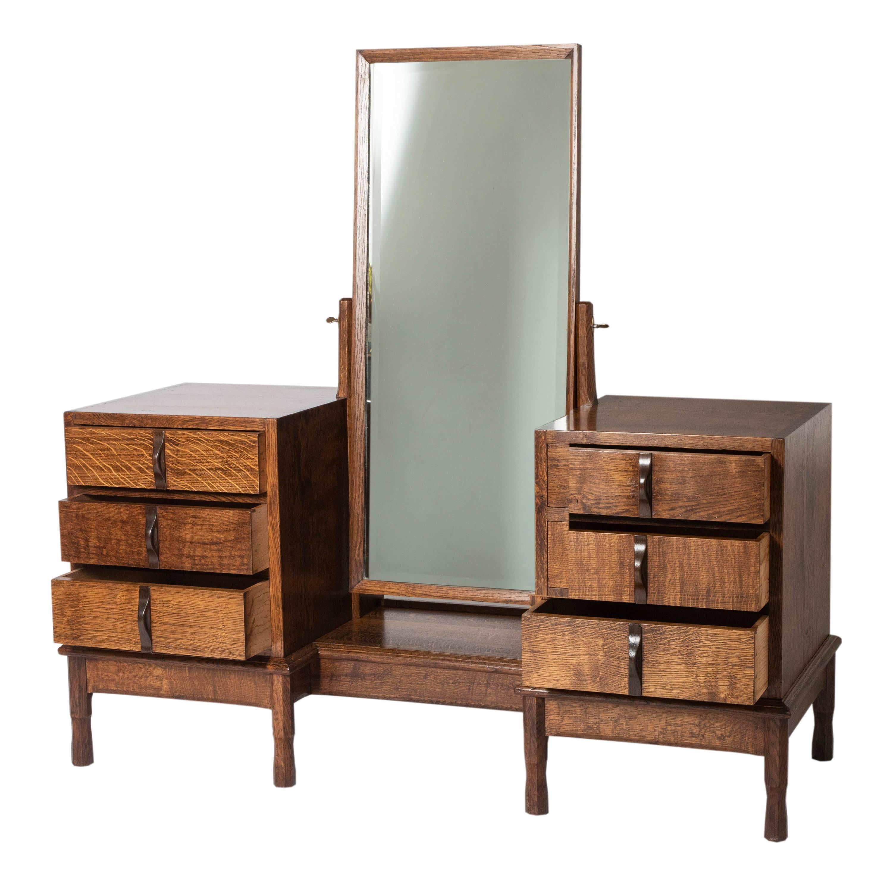 A Gordon Russell oak dressing table.
Mirror flanked with drawers.
Bog oak handles.
England, circa 1928
Measures: 140 cm H x 139 cm W x 53 cm D
Provenance: Purchased from Gordon Russell by Mrs Hart of Erdington as a wedding gift for her daughter