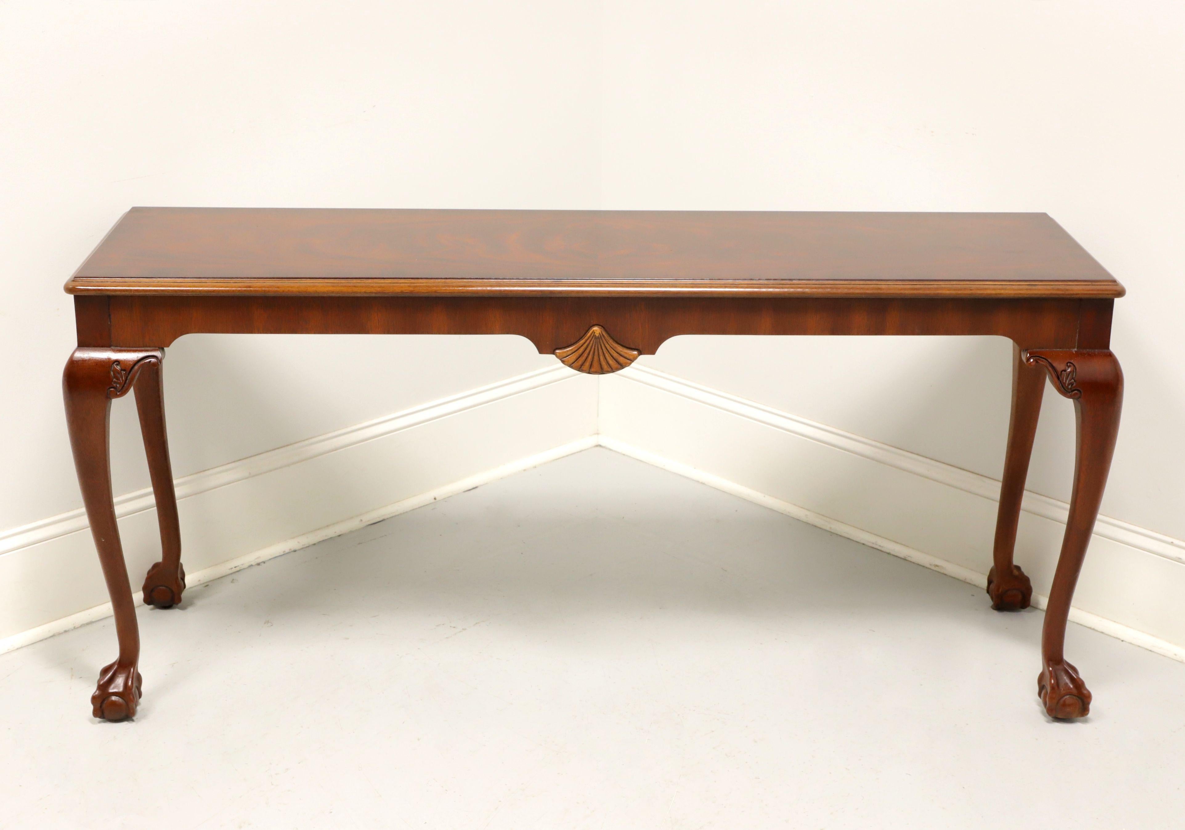 A Chippendale style sofa table by Gordon's Furniture, of Johnson City, Tennessee, USA. Solid mahogany with banded flame mahogany top, cabriole legs, carved knees, carved fan to front center and ball in claw feet. Made in the late 20th
