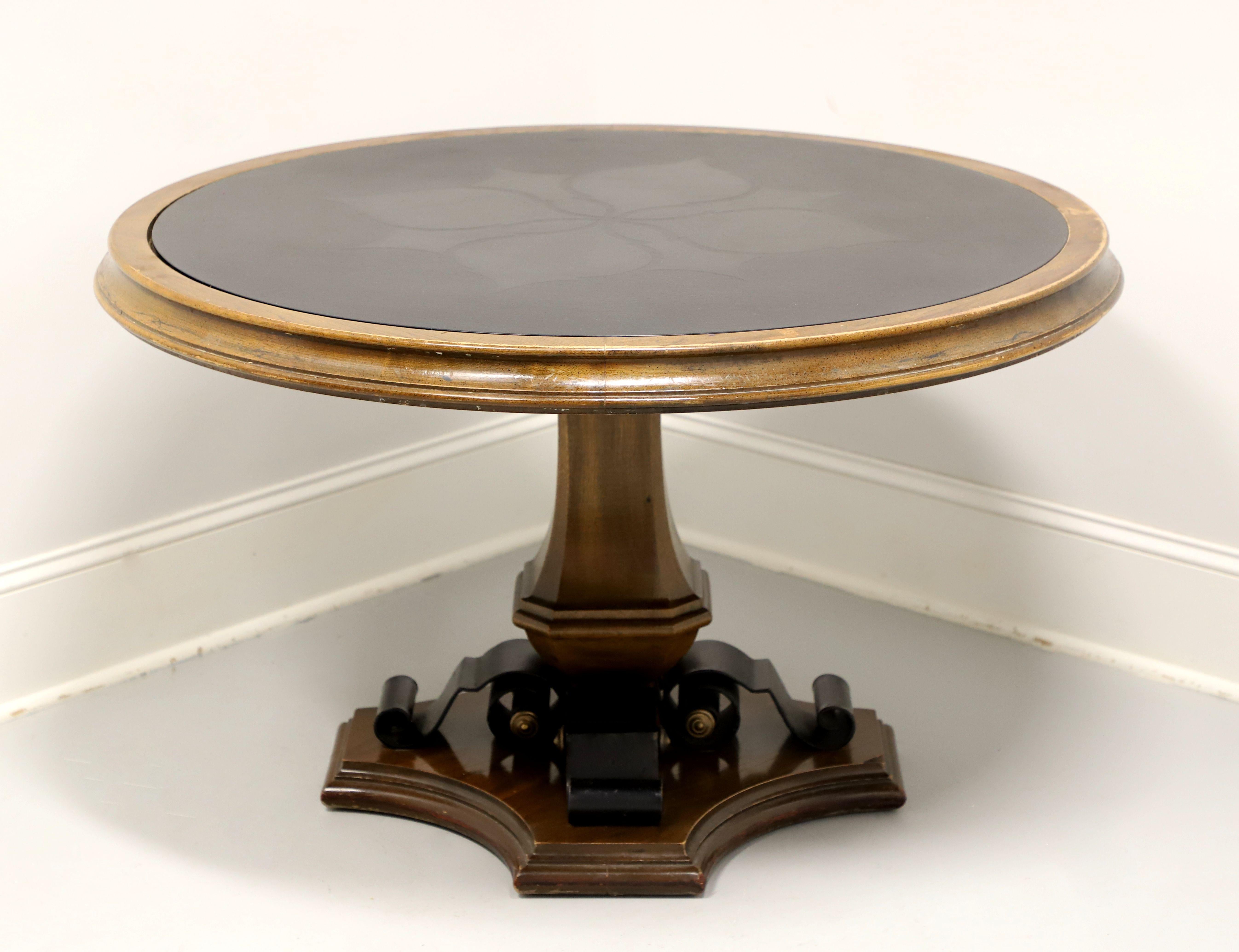 A Spanish style round game table by Gordon's Furniture, of Johnson City, Tennessee, USA. Walnut with an inlaid black composite material top, top has a decorative design to the center & a smooth edge, bevel edge to the apron, carved four-sided