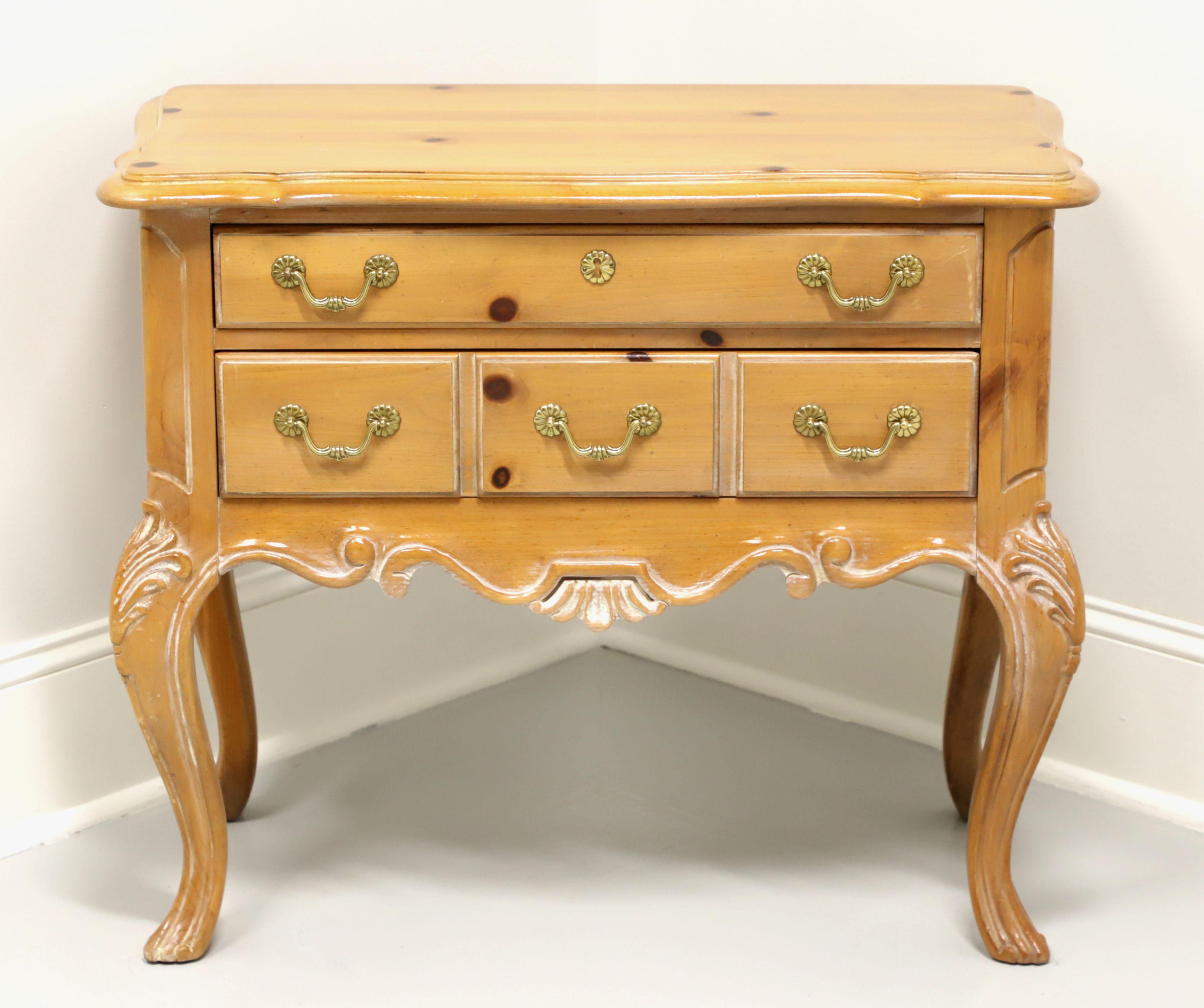 A French Country style lowboy chest by Gordon's Furniture, of Johnson City, Tennessee, USA. Solid pine with an antiqued finish, brass hardware, carved apron & knees and curved legs. Features two drawers of dovetail construction, upper with faux