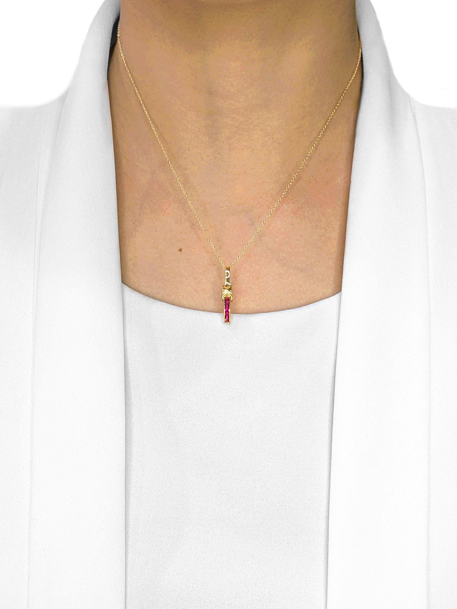 Crafted with elegance and detail, this 18K yellow gold pendant (with a 14K gold hook) showcases five princess-cut rubies, totaling 0.12 carats, radiating a vivid red hue that symbolizes passion and vitality. Accentuating the design are two round