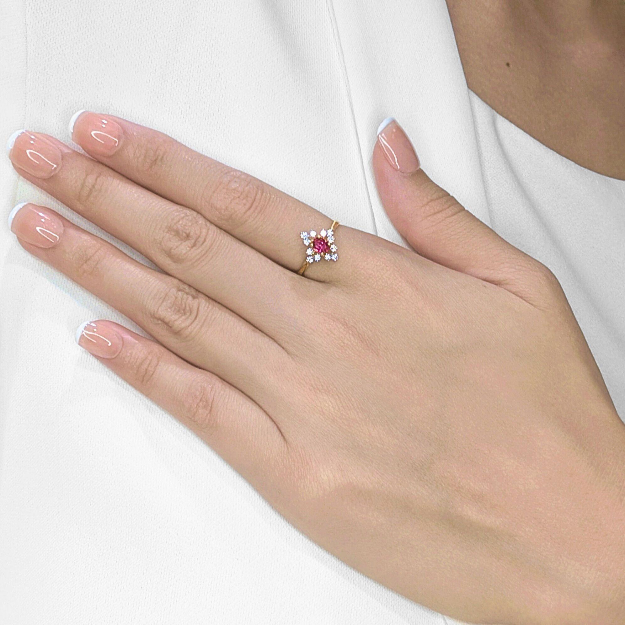 Cette nouvelle bague rayonne d'un charme intemporel. Elle est réalisée en or jaune 14 carats et ornée d'un rubis ovale de 0,18 carat d'une riche teinte rouge. Autour de lui, 12 diamants naturels ronds de taille brillant, totalisant 0,24 ct, brillent