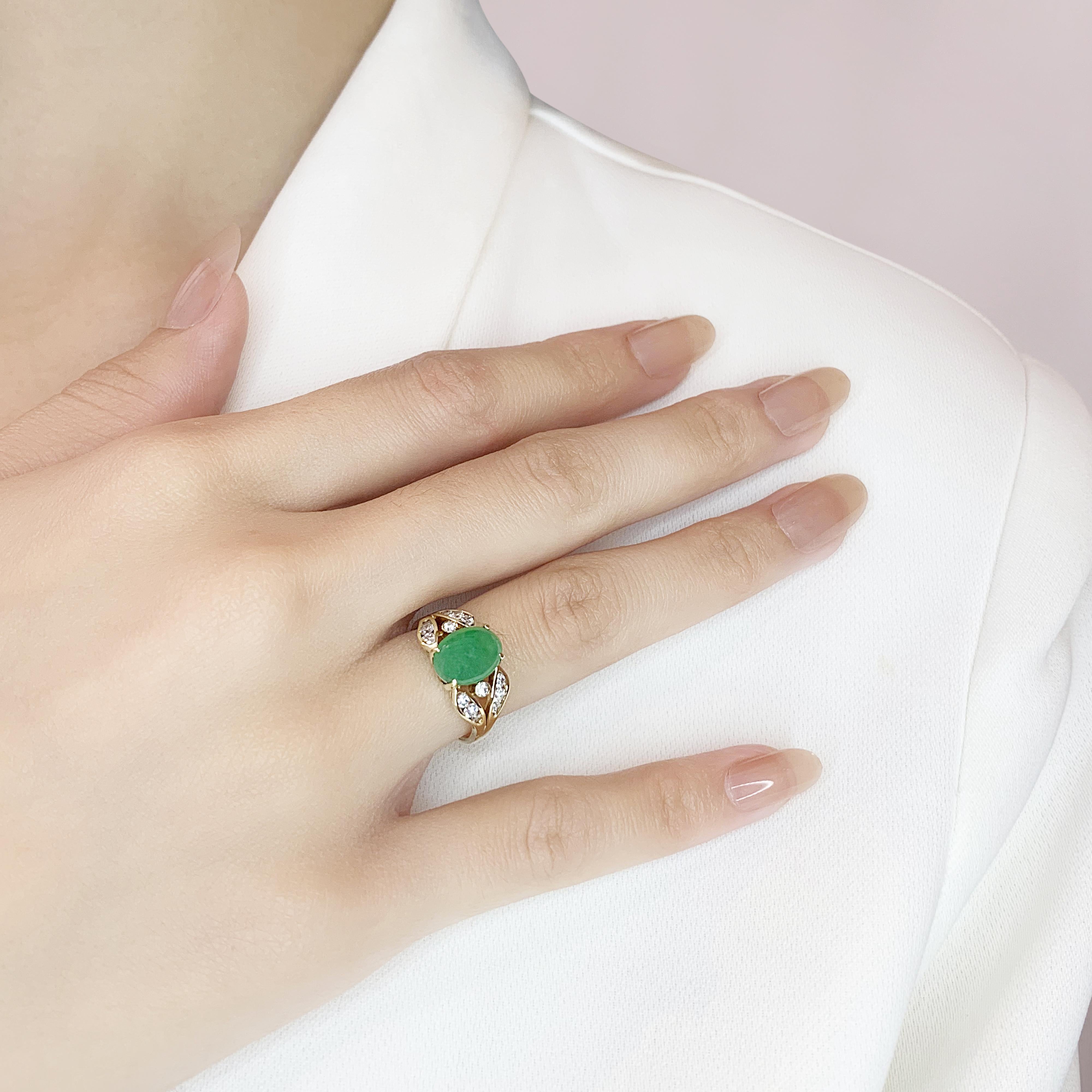 Cette majestueuse bague pave met en valeur un exquis jade vert de forme ovale comme pierre principale, pesant 1ct, serti dans de l'or jaune 14K. Le jade est complété par 14 diamants ronds de taille brillant, totalisant 0,2 ct, de couleur I et de