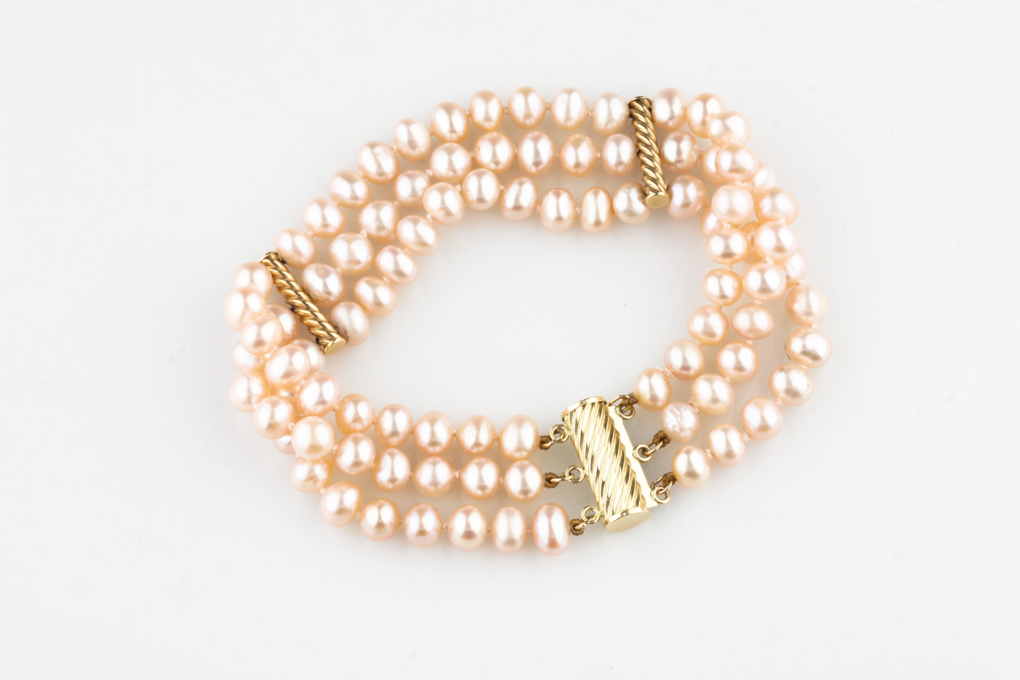 Wunderschönes dreisträngiges Perlenarmband
Mit leicht asymmetrischen Perlenketten
Rosafarben, silberner Perlmuttglanz
Durchschnittlicher Durchmesser der Perlen = 5 - 6 mm
Inklusive 14k Gelbgold Twist Akzente und Schließe
Gesamtmasse = 25,2