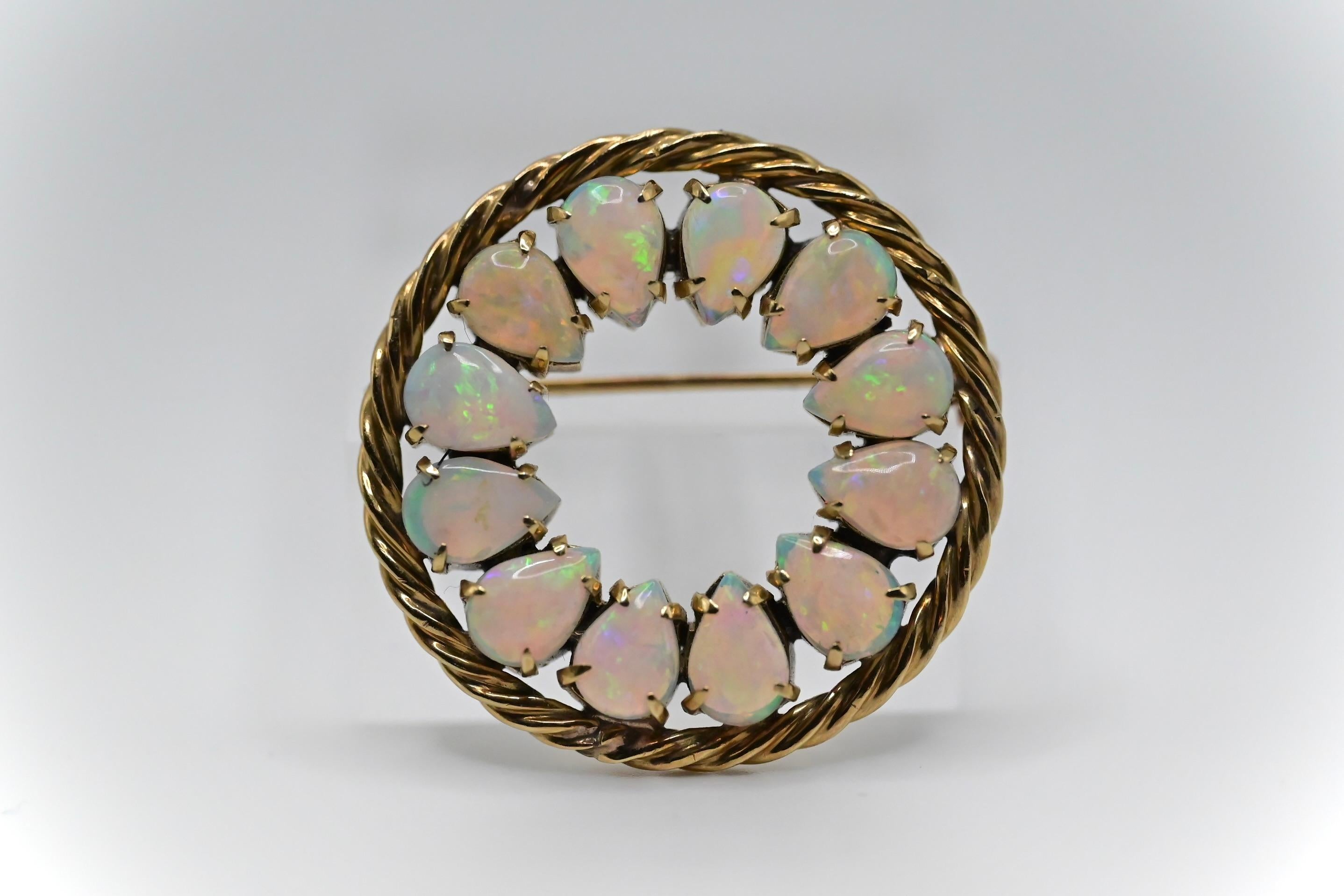 This is a gorgeous 14k yellow gold round brooch with 12 exquisite pear shaped opals placed around it. It’s in great condition with little to no signs of wear, and weighs 9 grams. The length and height of the brooch is 1 inch 2/8, and it’s about 4mm