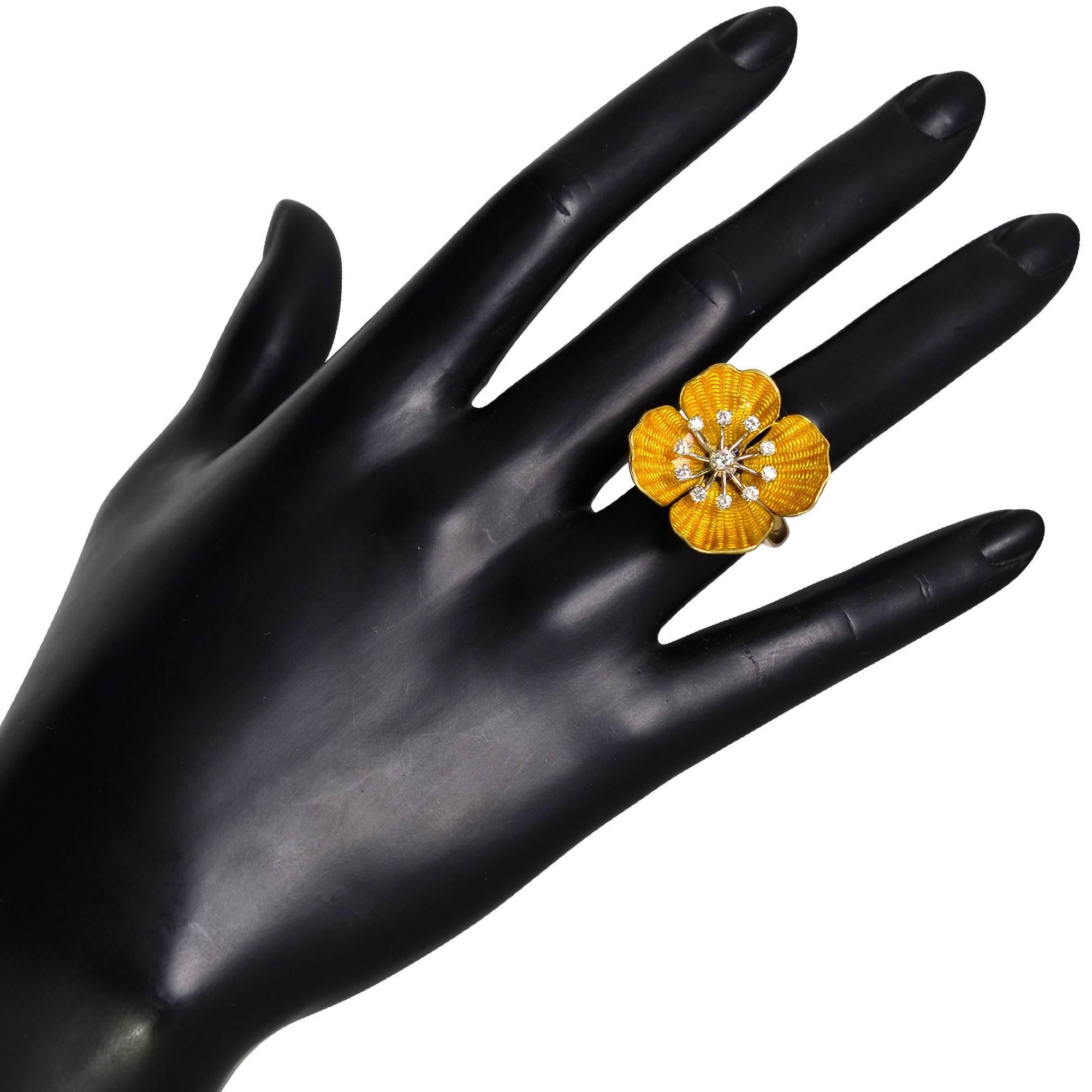Whimsical 18K yellow gold  flower cocktail ring showcasing 11 round brilliant cut diamonds weighing approximately .50cts F-G color and VS1-2 clarity surrounded by 4 gold petals adorned with vibrant orangey yellow enamel. The ring is currently a size