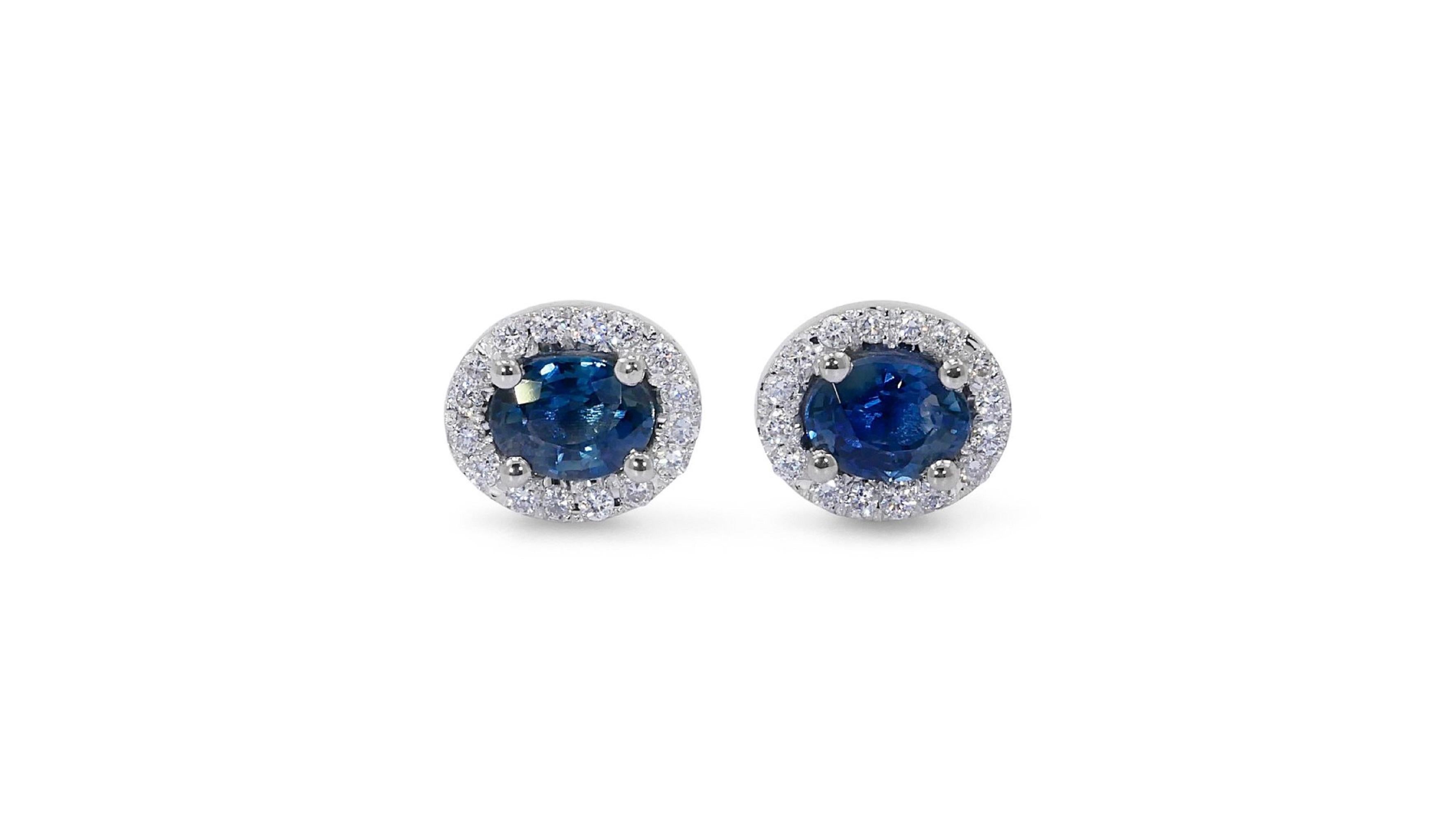 A beautiful pair of halo stud earrings with a dazzling pair of 0.70 carat oval sapphires. These earrings have 0.15 carat of side diamonds, which add to their elegance. The jewelry is made of 18K white gold with a high quality polish. It comes with