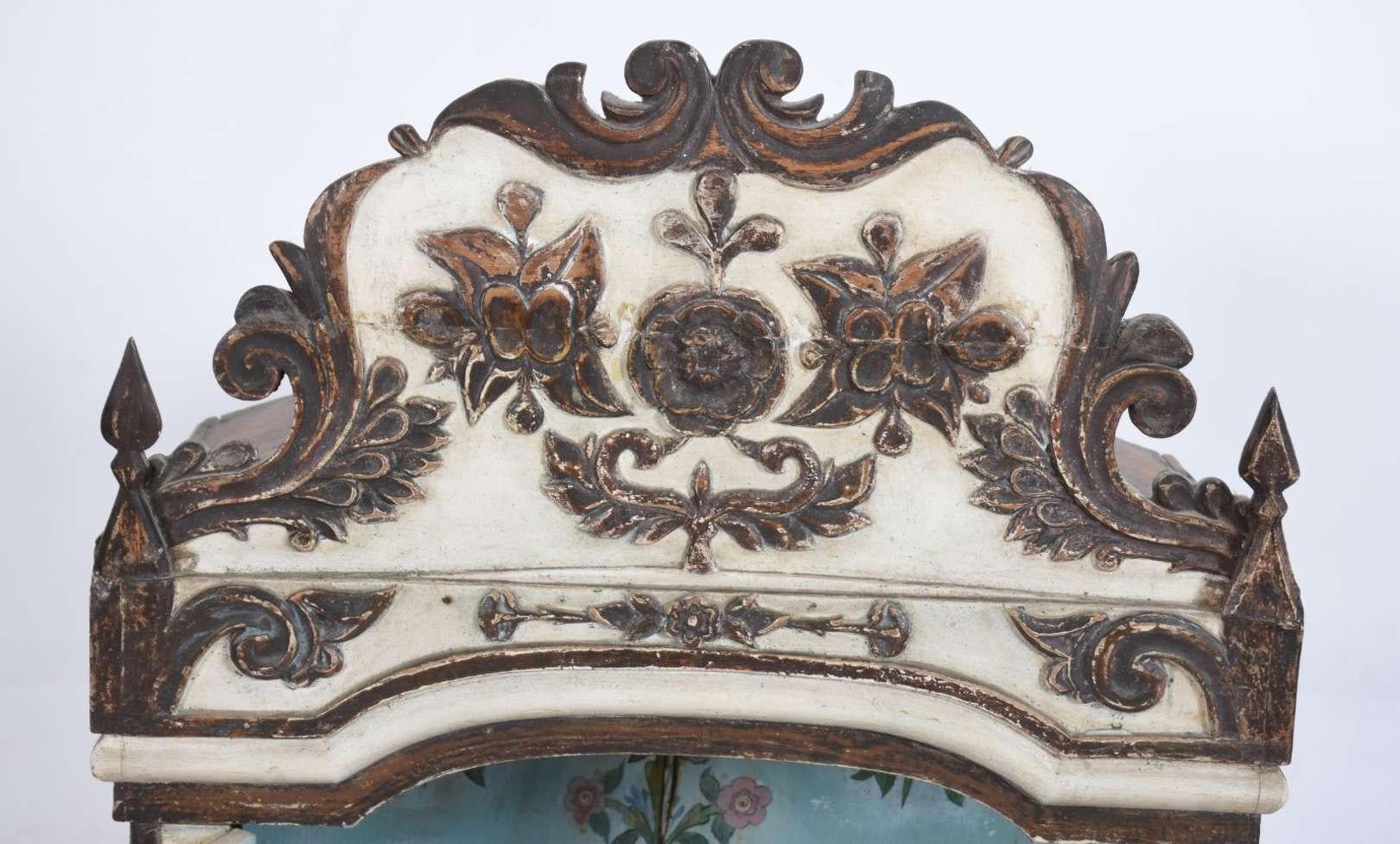 Belle châsse du XVIIIe siècle en cèdre polychrome. Boîte rectangulaire, surmontée d'un fronton sculpté de fleurs, flanquée d'une paire de pointes - comme des obélisques simplifiés. Les côtés et la paire de portes sont décorés de coussins avec des
