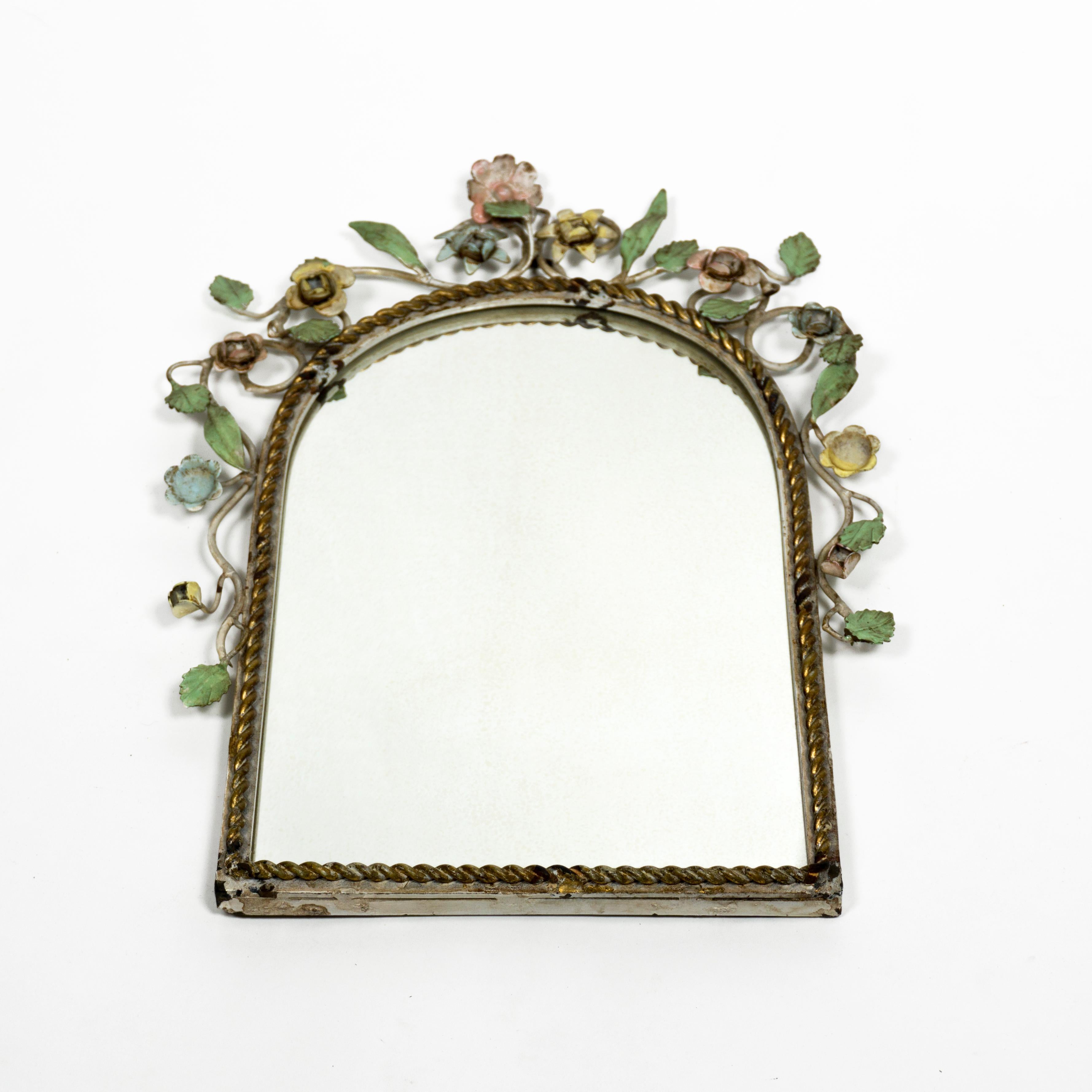 Lovely Mid Century Modern Tole mirror with white expanded metal frame and brass rim.
Highly decorative vintage italian Tole mirror from the 1950s.
The mid century modern wall mirror is decorated with hand-painted flowers and leaves – a beautiful