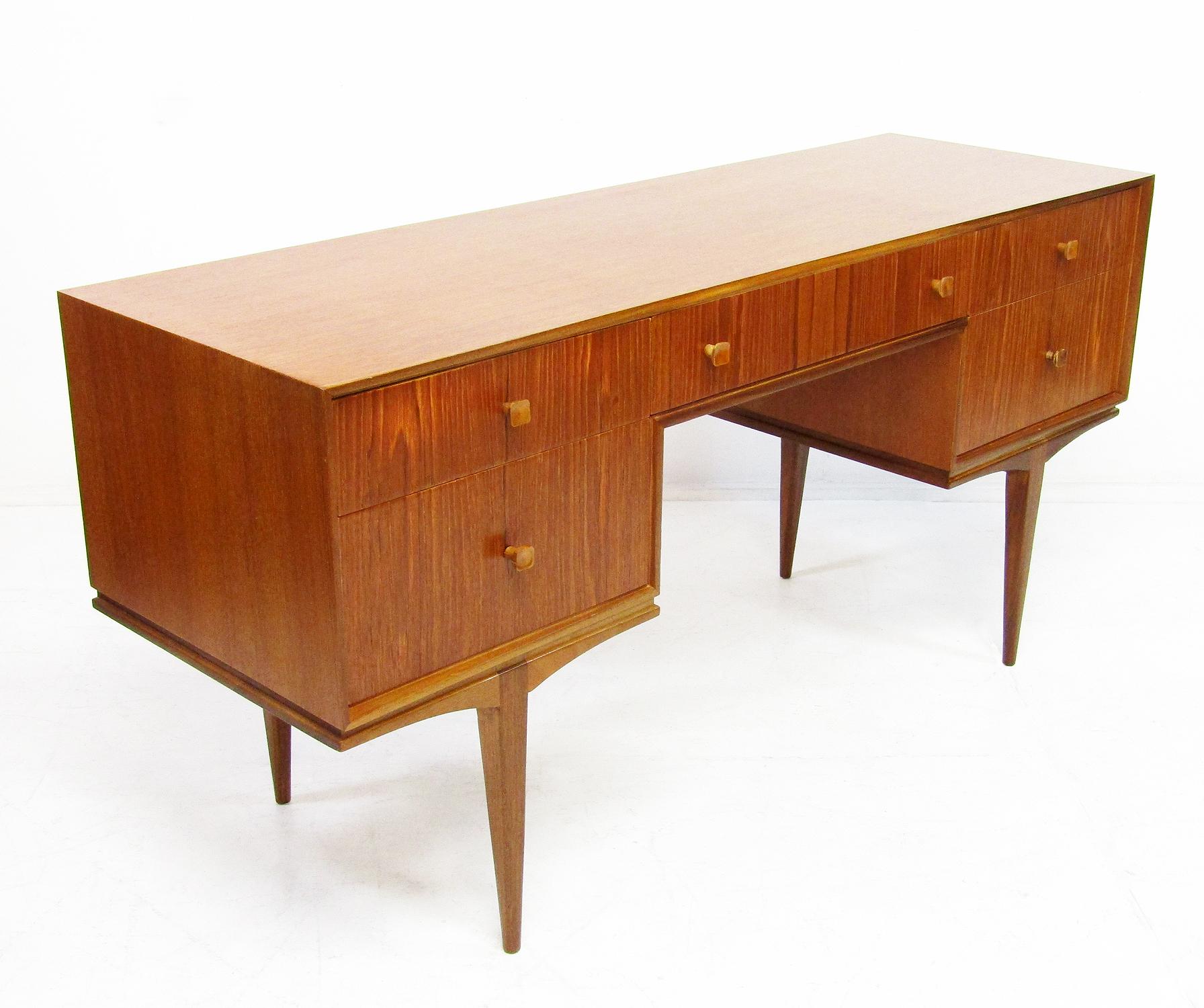 Gorgeous 1960s modernist desk or dressing table in teak by McIntosh of Kirkcaldy.

With the accompanying mirror, it can be used for either purpose. The large, impressive mirror can be detached and used separately.

McIntosh is ever more valued