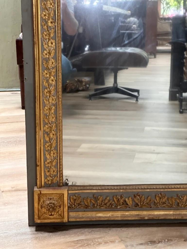 Authentic period boiserie panel mirror, 19th Century having a blue/grey background, a gilded frame with a floral and egg and dart border around a two-part glass original mirror), the bottom corners having medallions flanking an oak and acorn carved