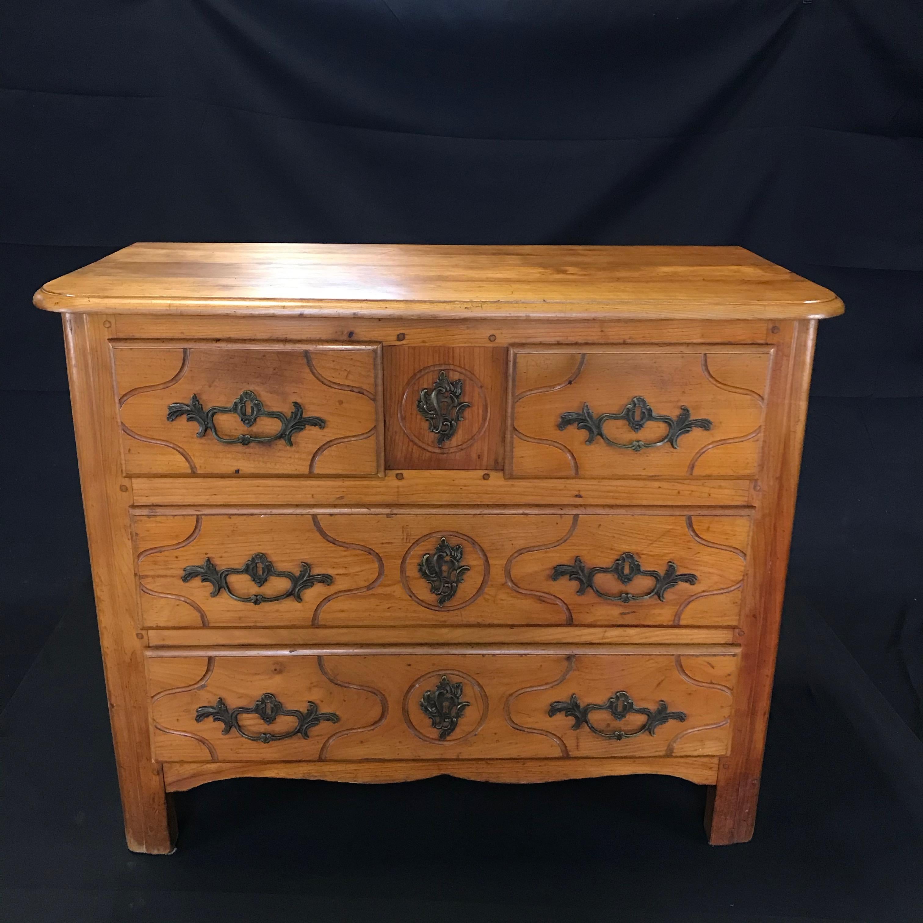 Gorgeous cherry antique chest of drawers having a shaped top with bevelled and banded edge over four front drawers which have shaped carved raised panels and lovely hand cast pulls and escutcheons. The sides have shaped raised panels as well. This