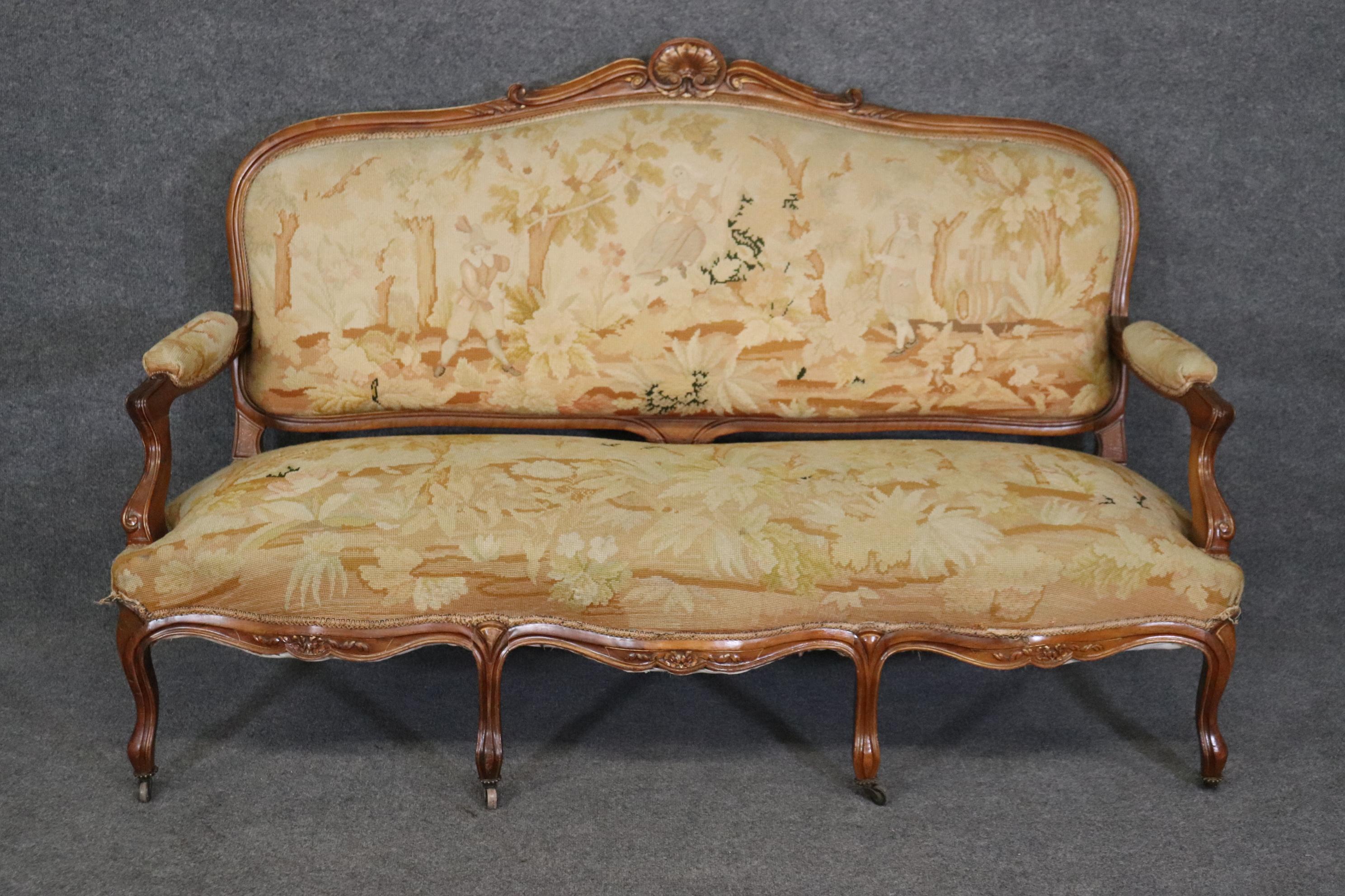 This is a beautiful carved walnut French Louis XV settee in needlepoint. The settee is in good condition with some stains on the back which is to be expected and the needlepoint is actually in rather decent condition with no major issues worth