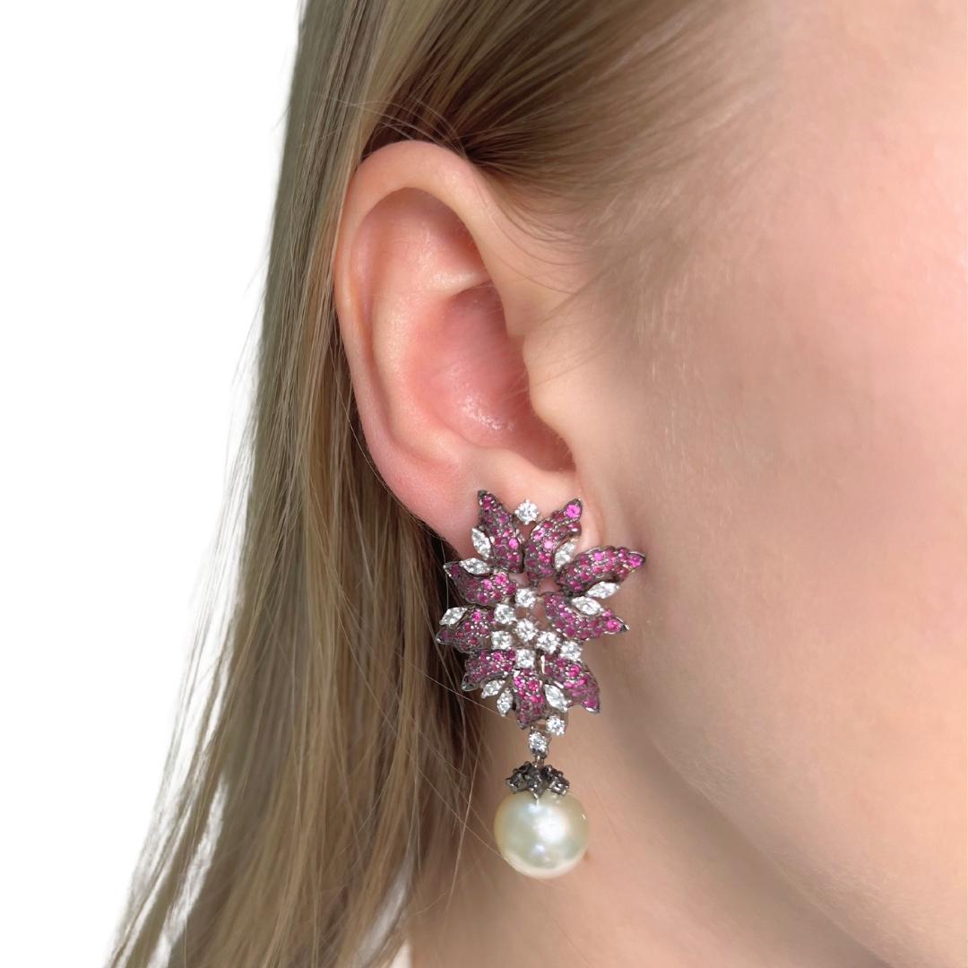 Gorgeous 24.64ct Salt Water Pearls, Rubies, and Diamonds Drop Earrings in 18k White Gold - IGI Certified

Experience luxury with these exquisite 18k white gold drop earrings, a masterpiece of elegance and vibrant color. The focal point features two