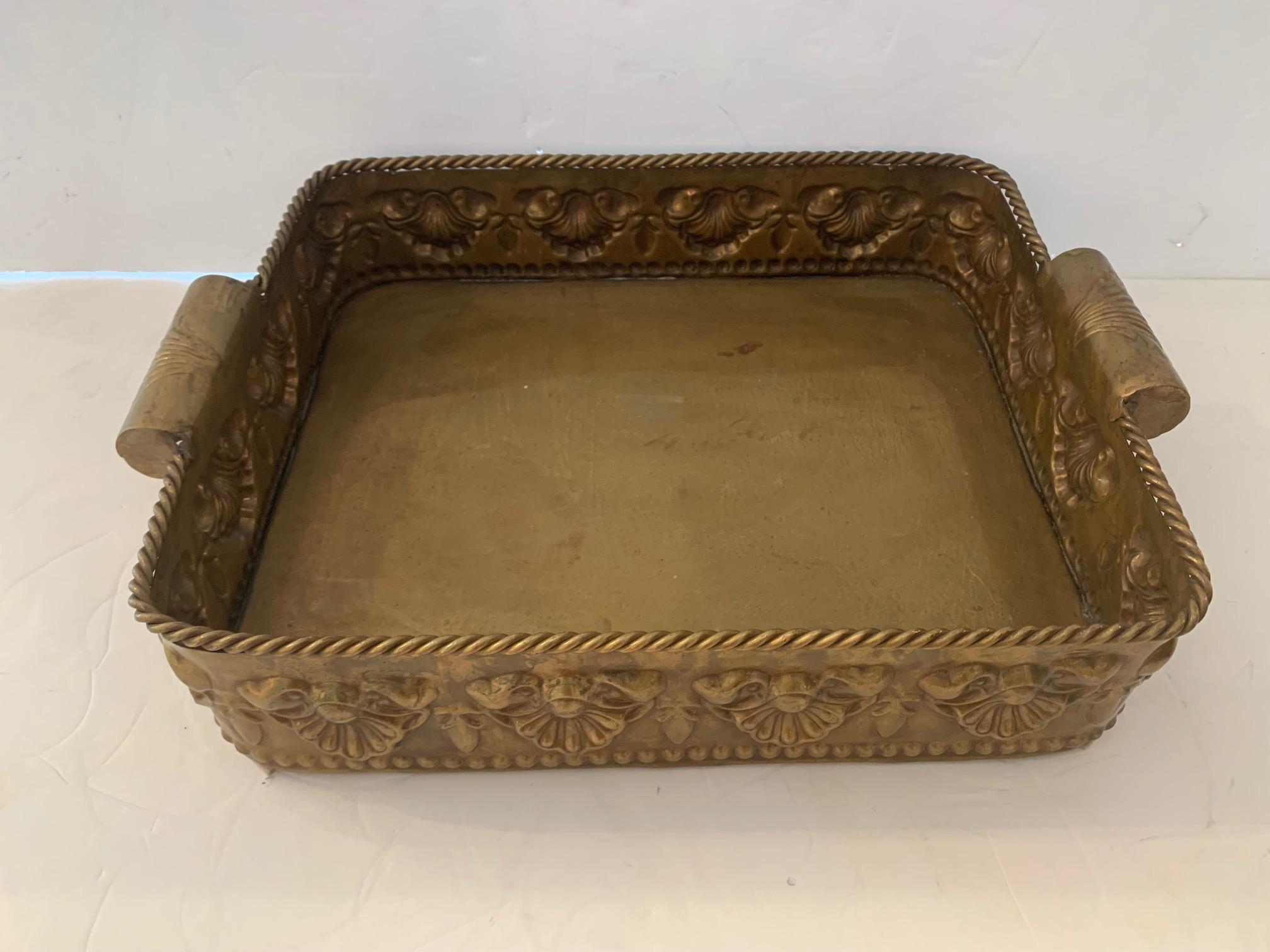A gorgeous deep brass tray having twisted rope adornment around the top, embossed clam shell design and chunky handles. Would make a great side table if on a custom stand.