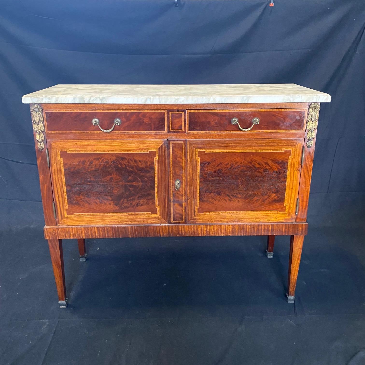 Antique French Louis XVI mahogany marble top buffet, sideboard or console with gilt bronze mounts represents the essence of the classical style celebrated especially during the latter years of the 19th century into present times. This buffet or