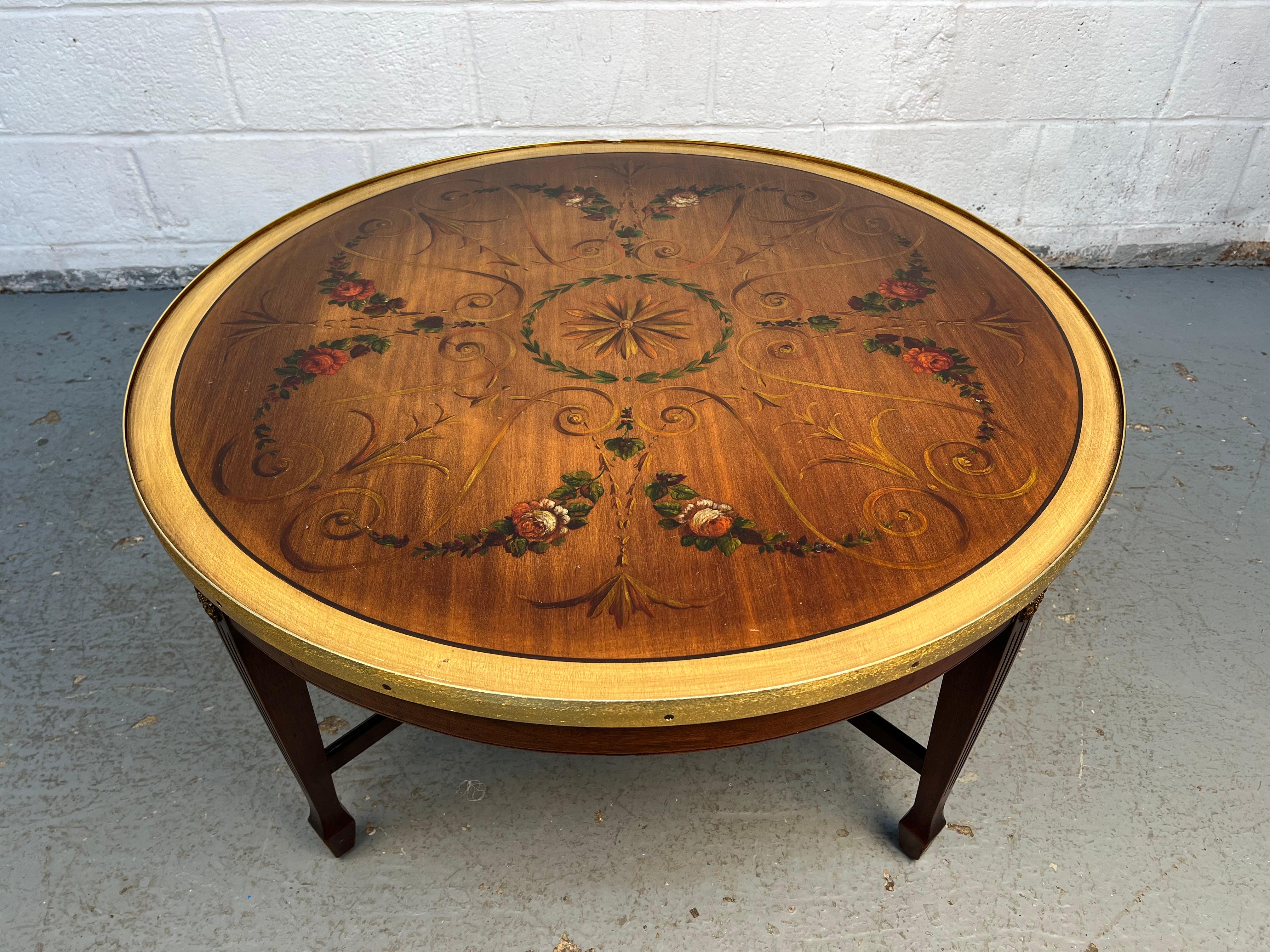 Magnifique table basse en acajou, dotée d'un cadre en bois richement grainé, d'une bordure en laiton et de magnifiques peintures ornementales sur le plateau de la table. Les œuvres d'art décoratives ajoutent du charme et de l'individualité, tandis