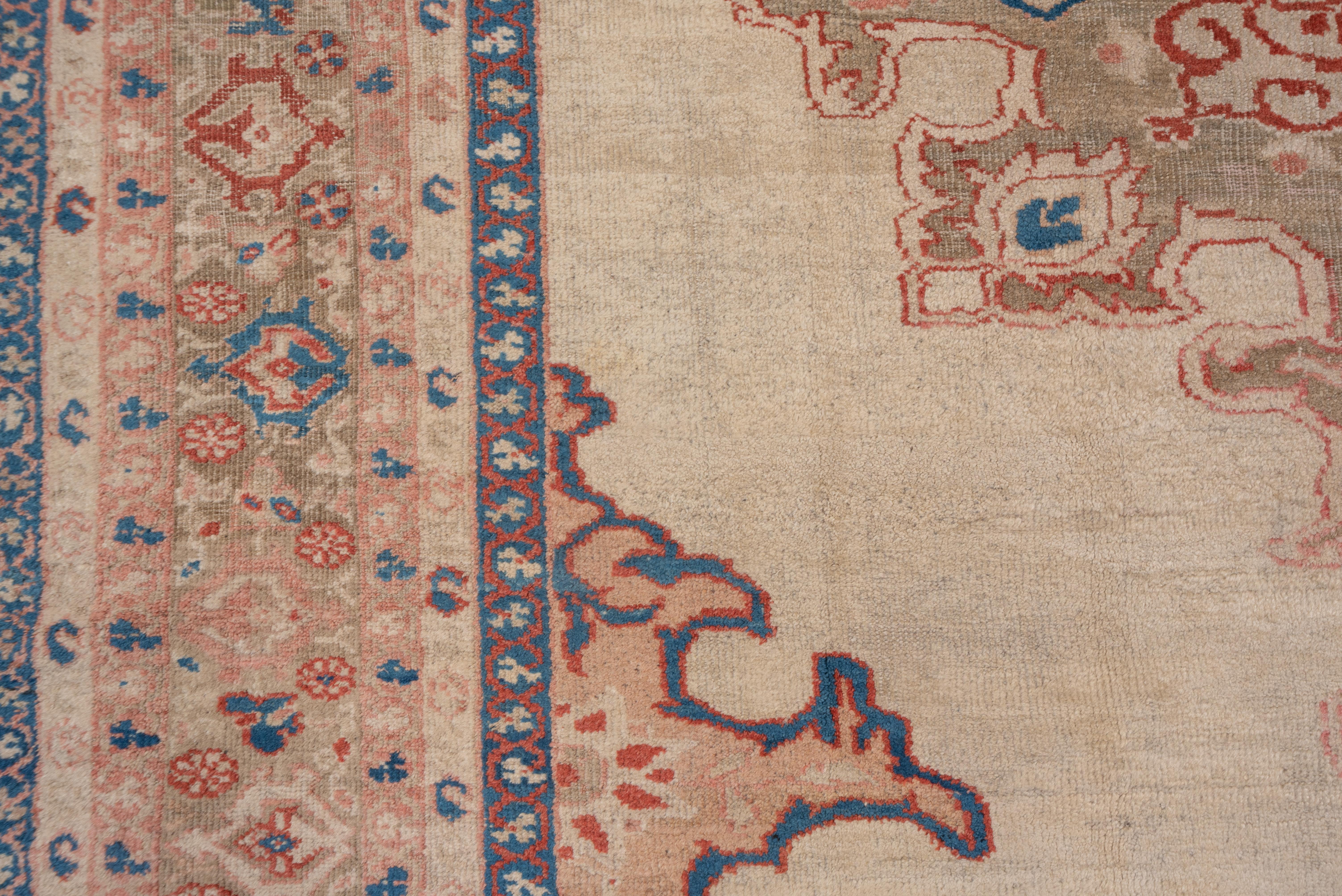 The ragged and torn corners are edged in dark blue and are exactly copied in outline mirrored in the cerulean-accented medallion set on the cream, open ground. West Persian rustic carpet with a reversing, stylized turtle palmette border.