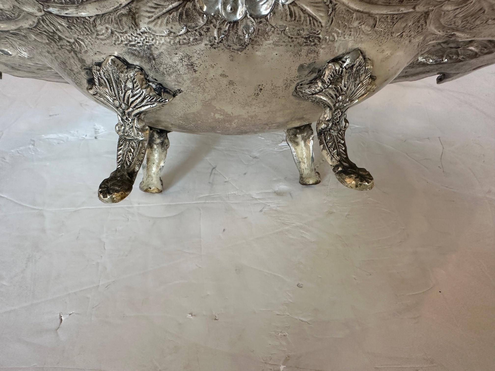 Elegant ornate silverplate repousee bowl compote having blossoms, shell forms, scroll handles and splayed feet.