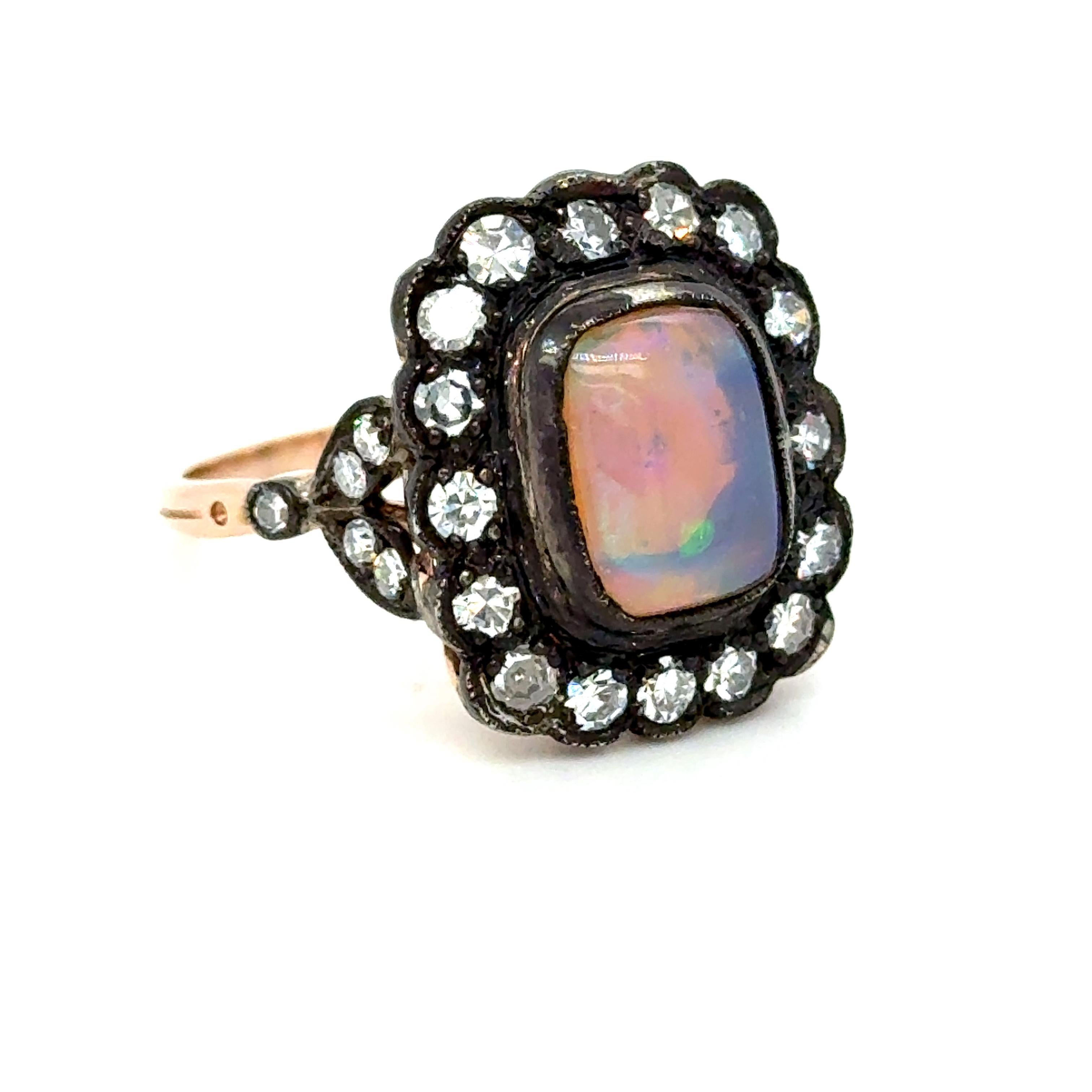 Cette magnifique bague victorienne ancienne à halo d'opales et de diamants a certainement attiré mon attention ! Réalisé en or rose 18 carats et recouvert d'argent, ce modèle présente un magnifique halo de diamants autour d'une superbe opale ! Au