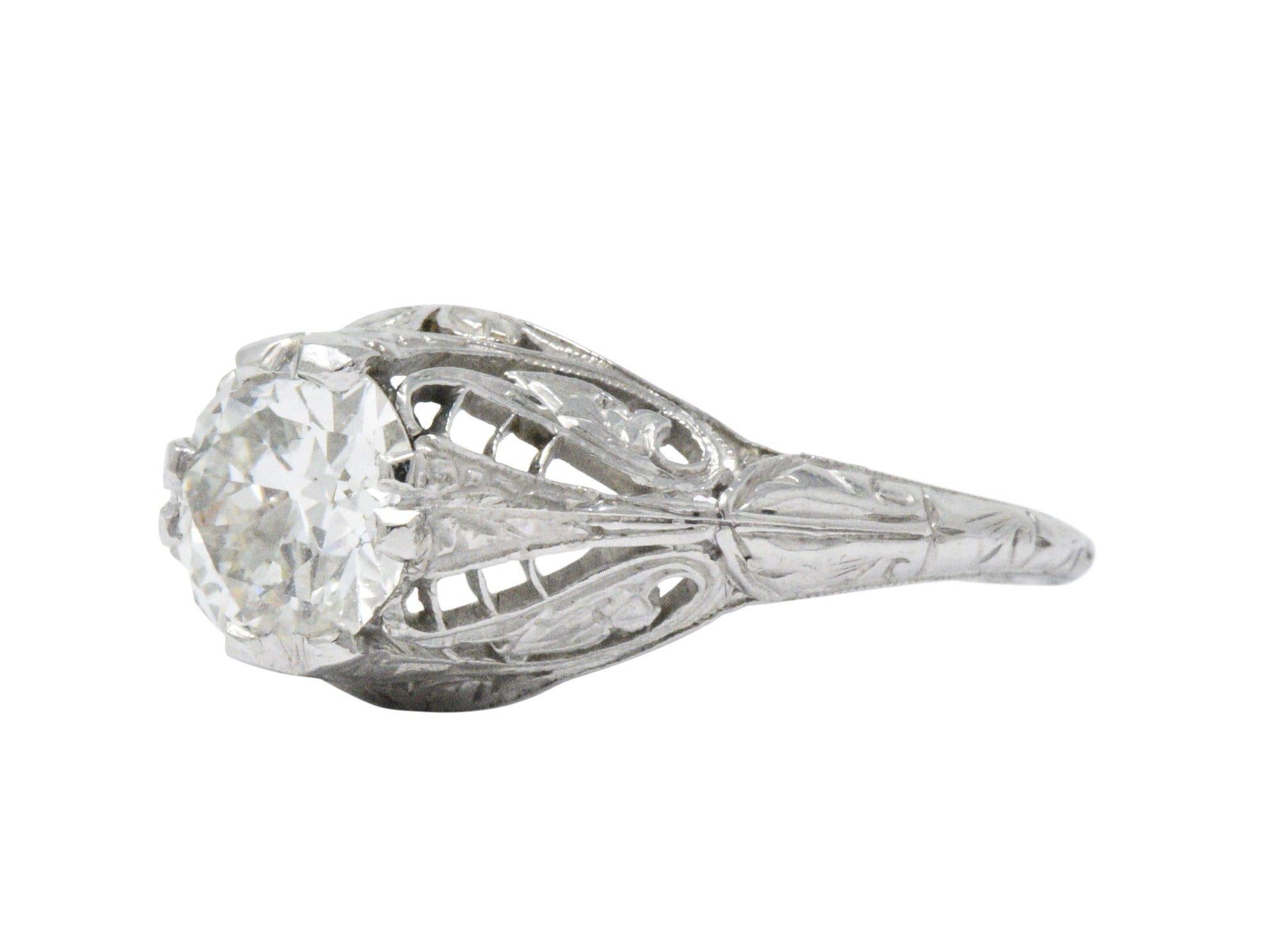 Centering a round brilliant cut diamond weighing 1.09 carats, K color and VS1 clarity

Prong set low in pierced mounting by stylized leaf-like prongs 

Completed by ornate gallery and engraved foliate details

Tested as platinum

Circa: 1920s

Ring