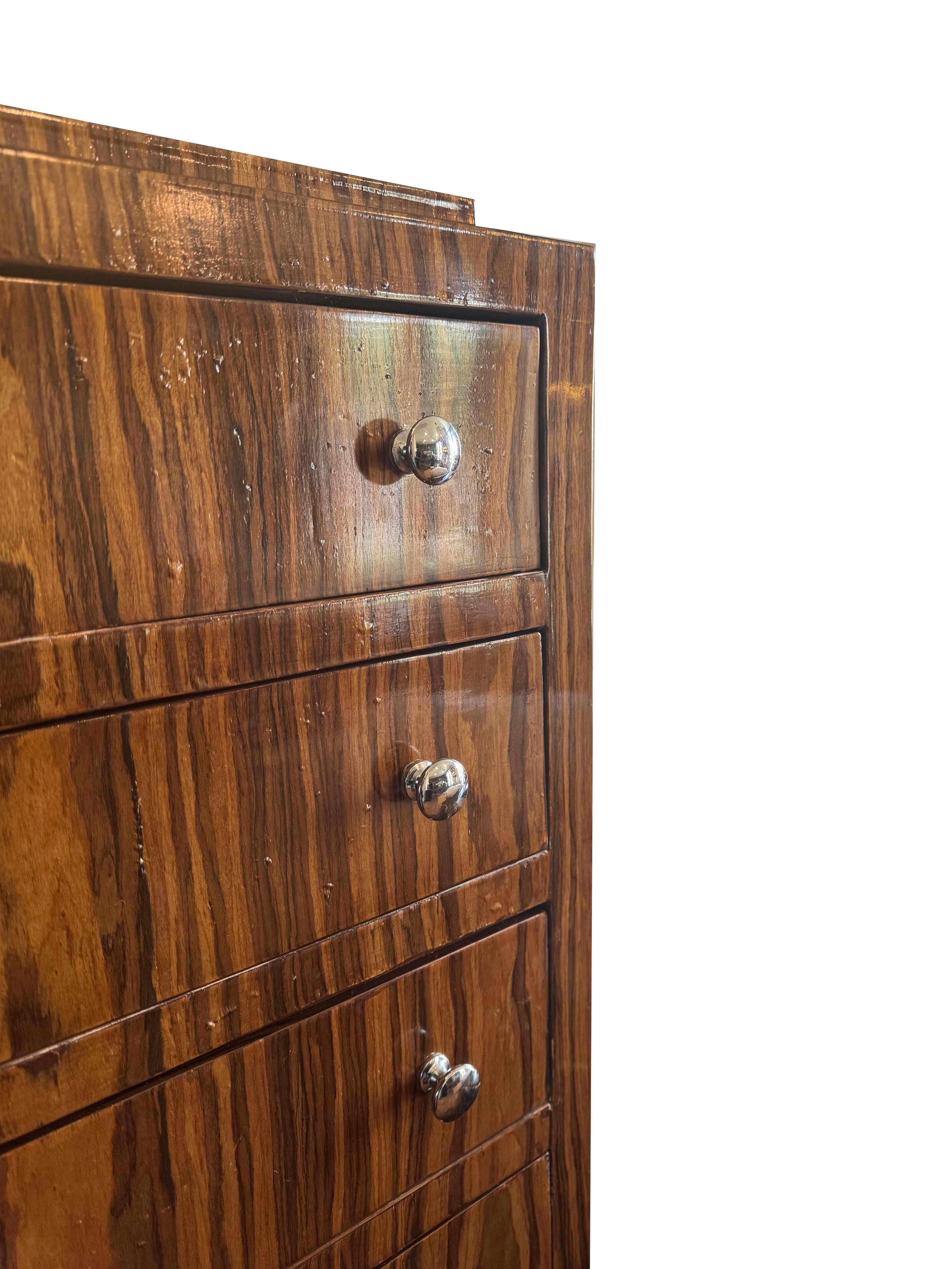 Elevate your home decor with this stunning lacquered Rosewood Art Deco tall chest, a piece that beautifully marries vintage glamour with modern sophistication. Comprising five spacious drawers, each accented with polished chrome knobs, this chest