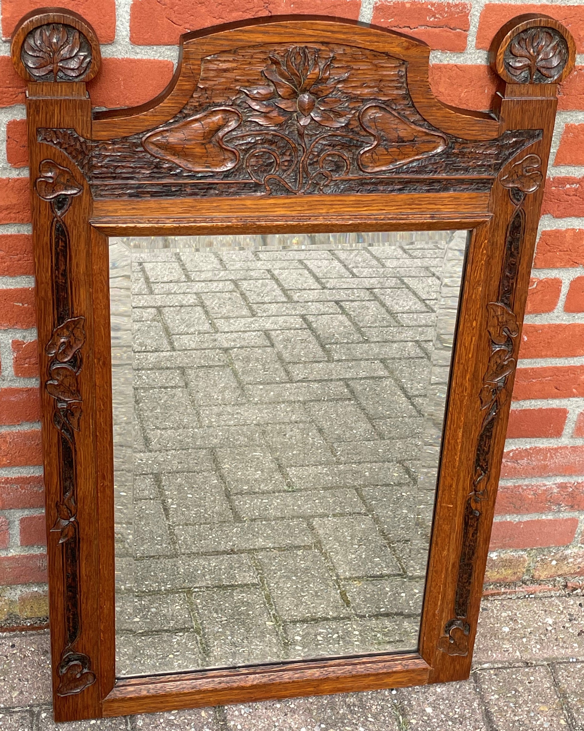 Good size and top quality carved oakwood frame with original, antique beveled glass mirror.

Over the years we have sold a number of great quality and unique mirrors and this fine Arts and Crafts specimen is right up there with the best. The first