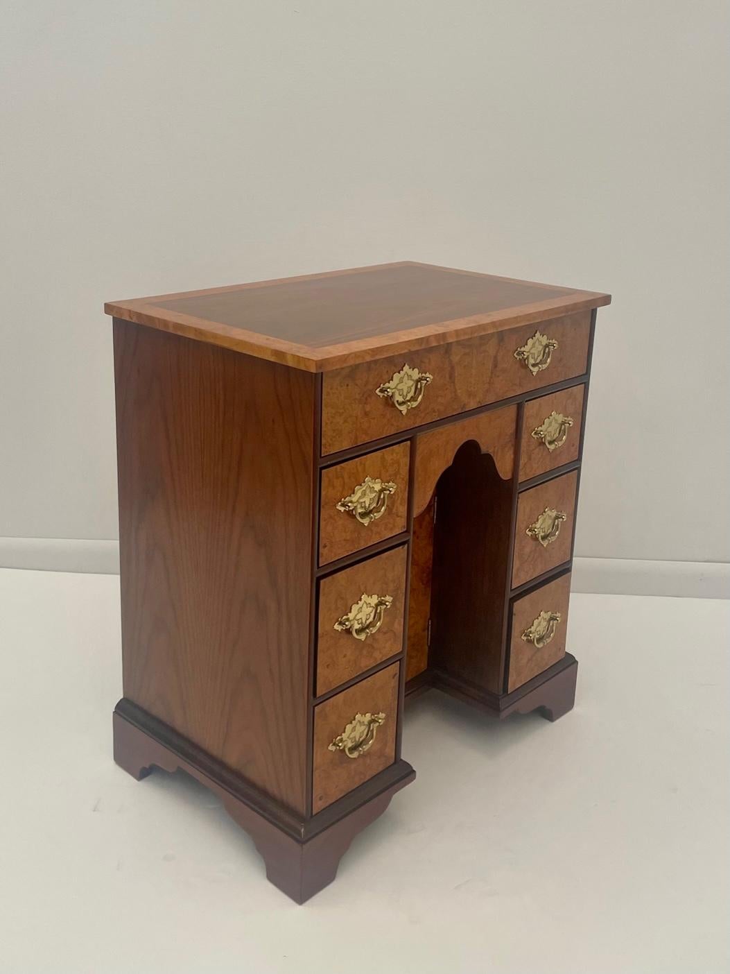 Gorgeous rich looking Baker Stately Home Collection Queen Anne style small chest or commode having walnut & burl veneer, 7 drawers, elegant brasses and little door in the recessed center for secret storage.  Chest is modeled after one in an English