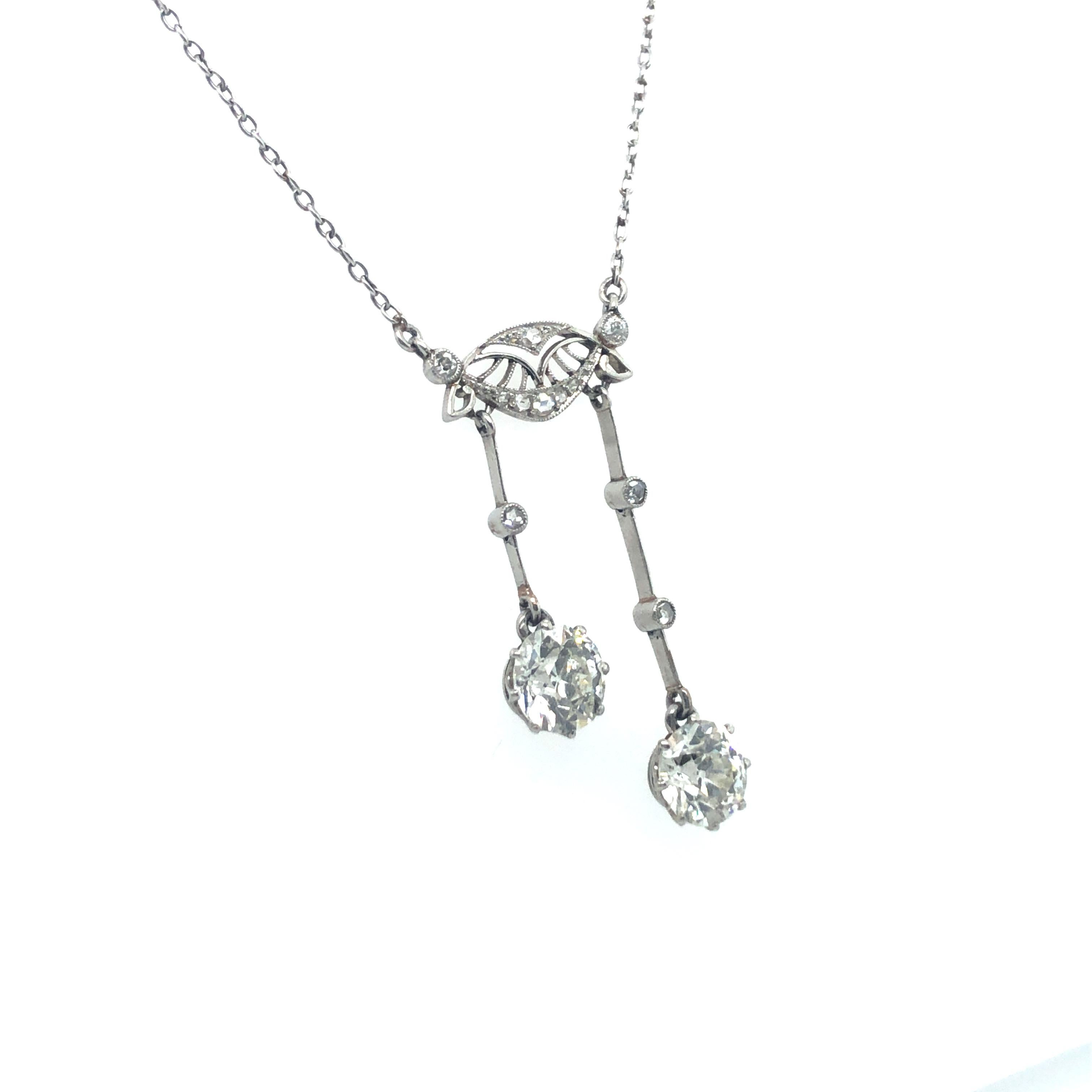 This beautiful Belle Époque négligée necklace enchants with its delicate and elegant playfulness.
Two old European cut diamonds of J/K colour and vs clarity with a total weight of approximately 2.10 carats swing from a finely pierced central section