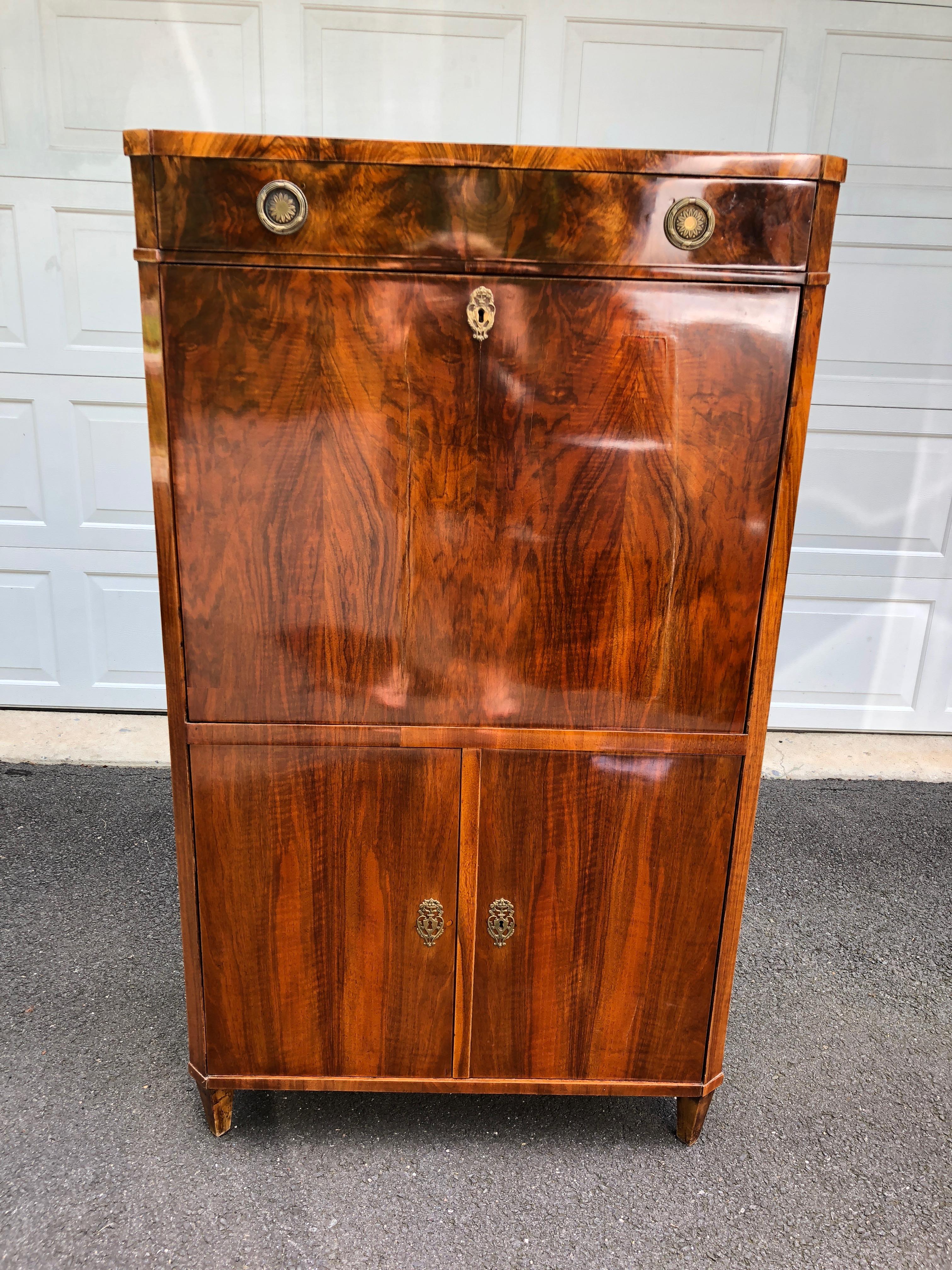 Beautiful secretary cabinet, circa 1825, Vienna, having black walnut veneer as well as a mix of cypress, oak and pine. Handsome ebony columns frame a hidden compartment. Not visible and hand written on the inner carcass 