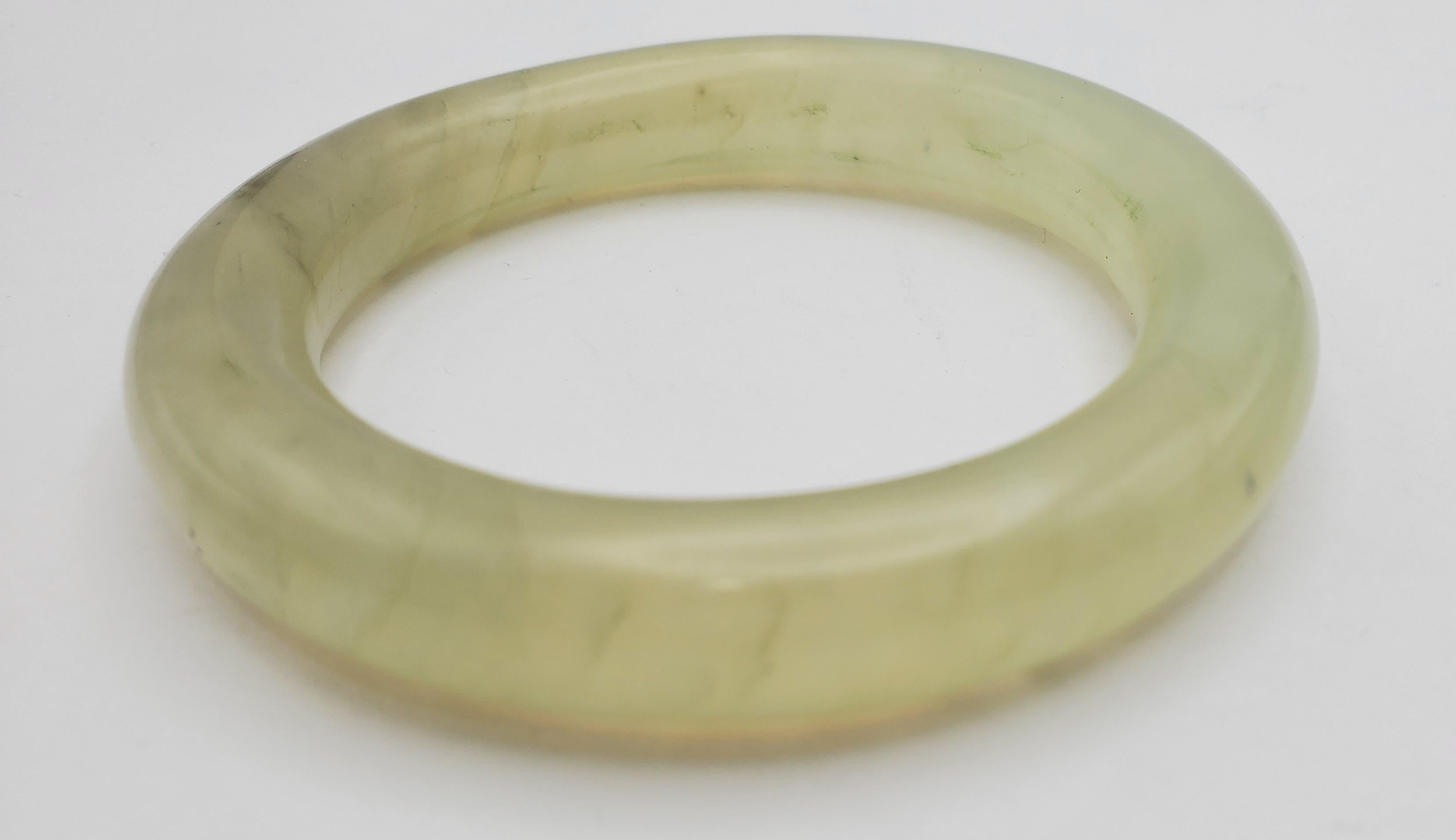 This beautiful natural Serpentine/Bowenite bangle has a translucent pale greenish color. The bangle is smooth on all surfaces to highlight the natural properties of the stone. Serpentine or Bowenite has recently been referred to as 