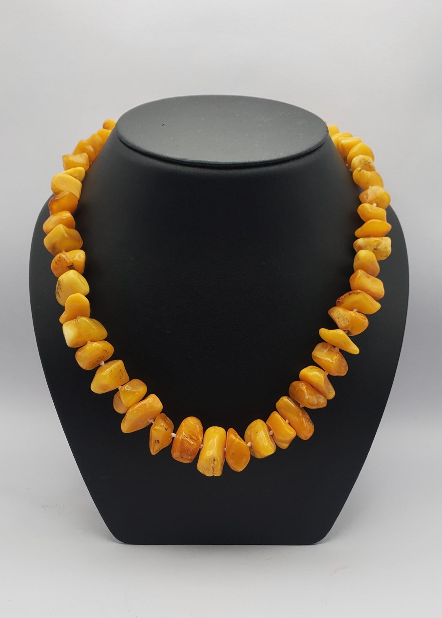 Gorgeous vintage butterscotch Baltic Amber bead necklace from the 1930s. The opaque warm honeycomb colored beads are strung continuously with knots in a graduated design. The strand is 26 inches long to comfortably fit over the head. There are some