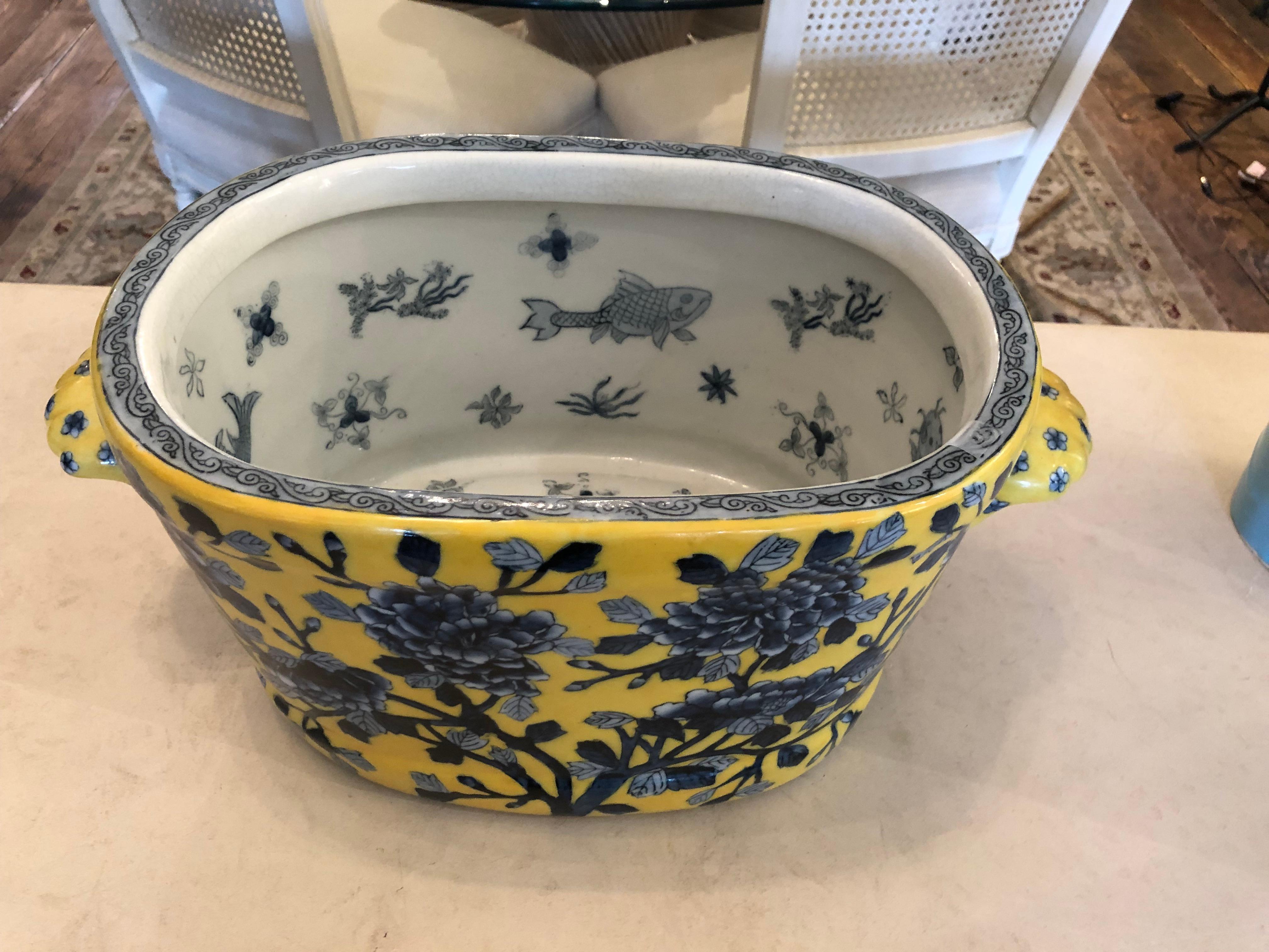 Lovely large oval planter footbath or centerpiece having beautiful Provencal color palette of yellow and blue with sculpted clam shell shaped handles. 
 Chinese mark on bottom,
Interior is blue and white with koy fish decoration.   Peonies adorn the