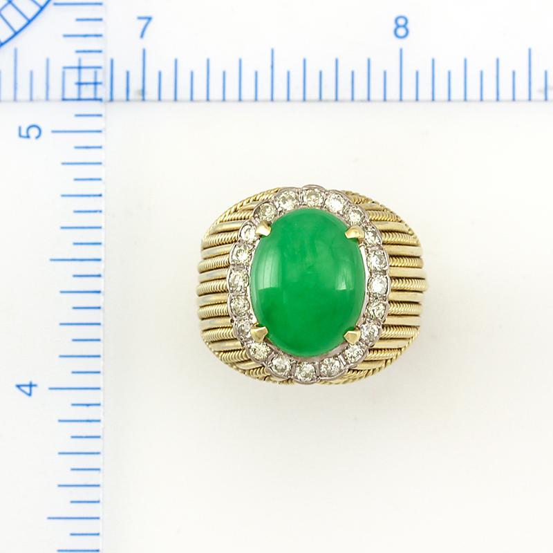 What an amazing Estate piece with one of the most beautiful ring shanks you will ever see!
The centerpiece of this beauty is a natural, untreated green jadeite jade cabochon - approx. 11x14mm - set in a 14K yellow gold 4-prong mounting with a