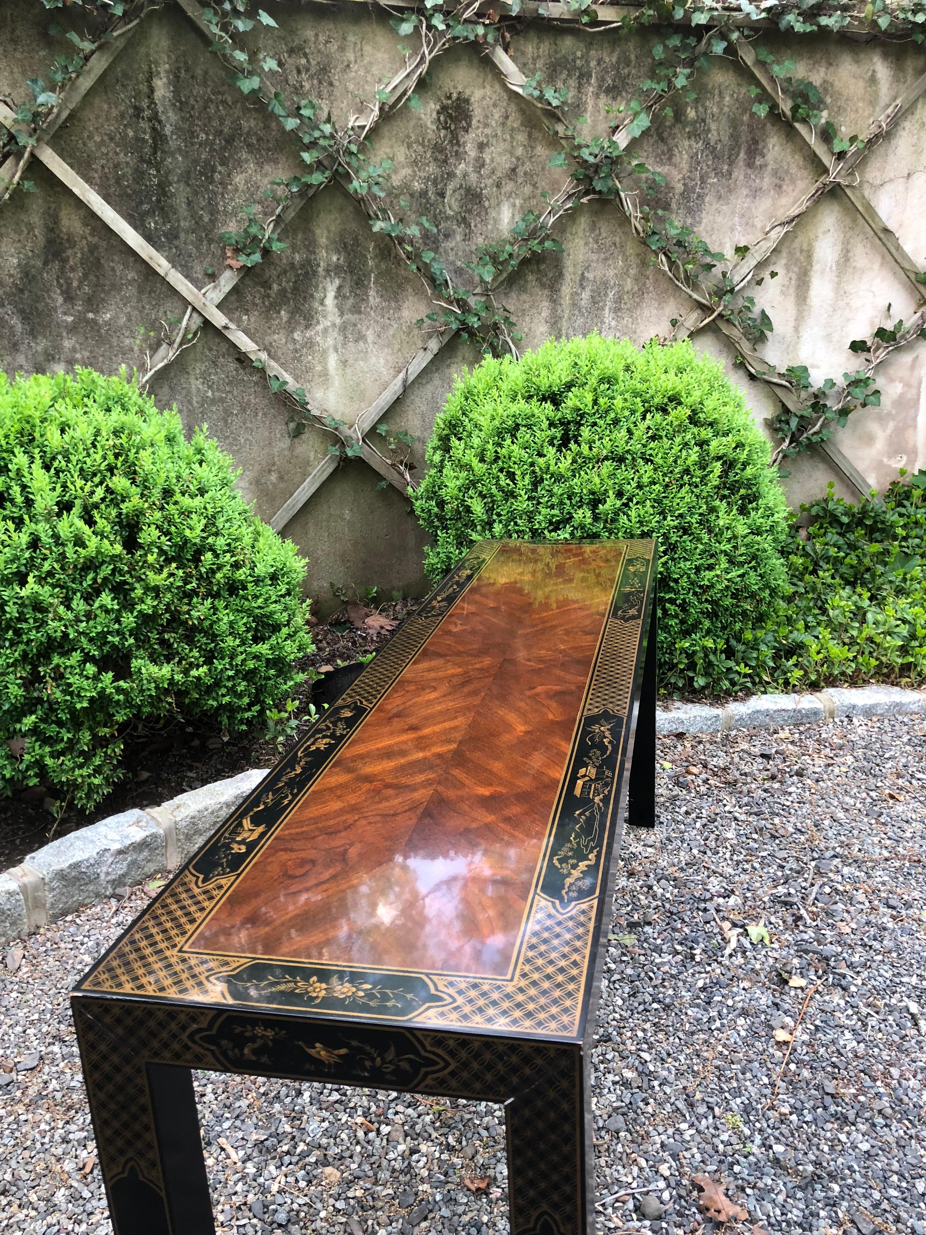 Sophisticated chinoiserie lacquered console having ebonized and lacquered mahogany with hand painted scenes and stencilling. The table is Parson's style, having clean, simple lines. Hand painted detail on each leg. The grain of the wood is beautiful