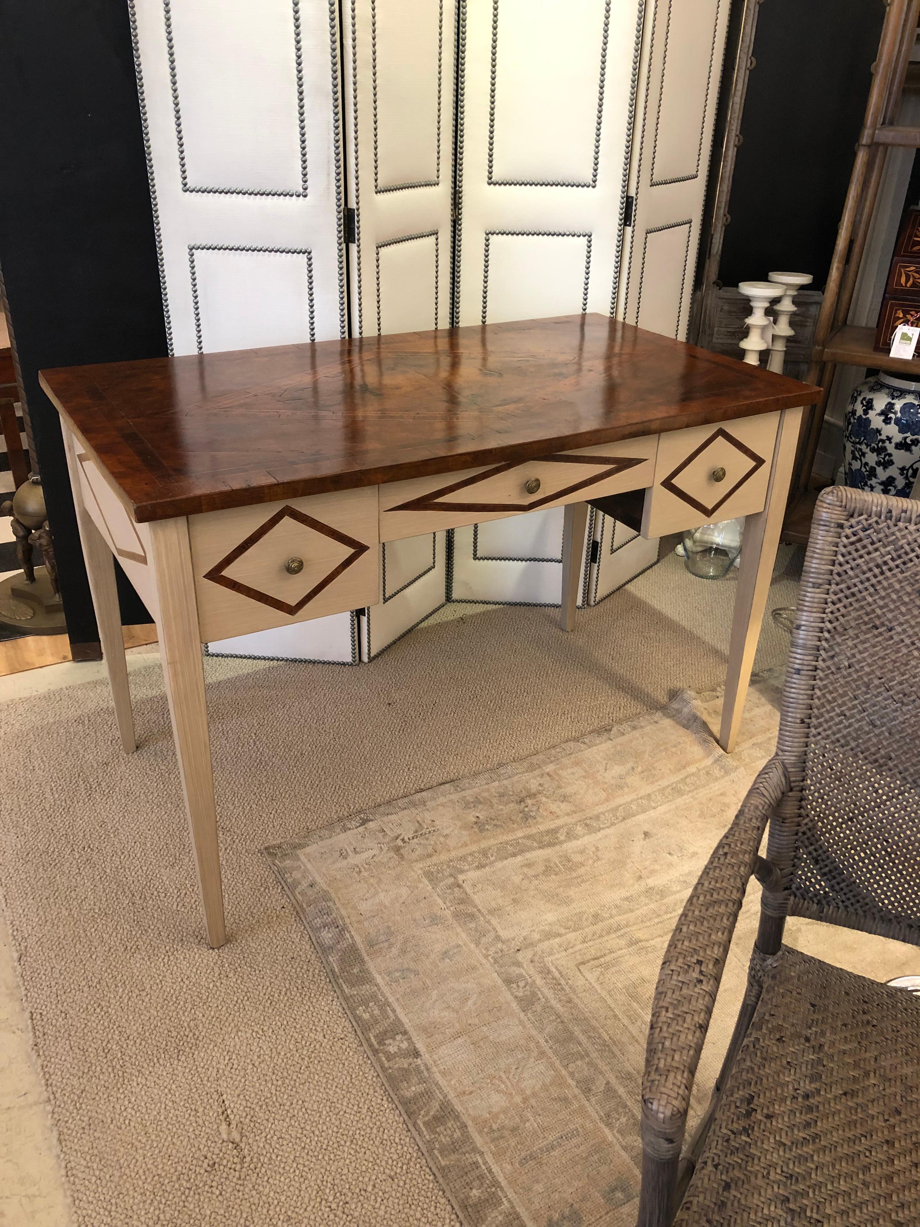 Stunning custom Discoveries writing desk by Bennetts Furniture having an off-white antiqued painted dragged finish offset with rich walnut inlay having a triangular motif and mouth watering burled walnut and inlaid top. The 3 drawers are walnut