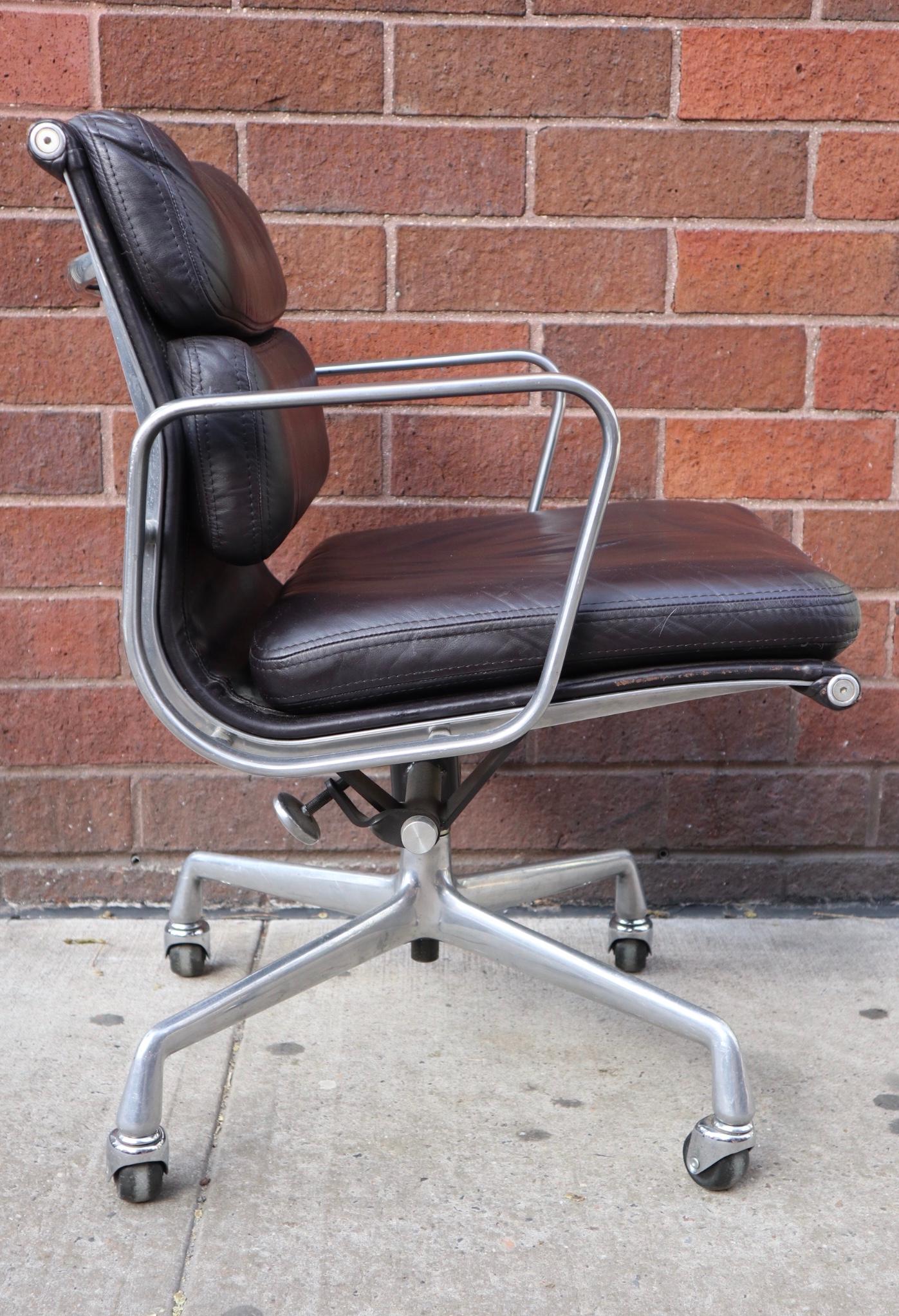 Fantastic Eames soft pad management desk chair. Gorgeous deep chocolate color on 4 star polished aluminum base. Chair swivels and tilts smoothly Signed Herman Miller. All wheels function without issue. No tears to the leather. In lovely shape with