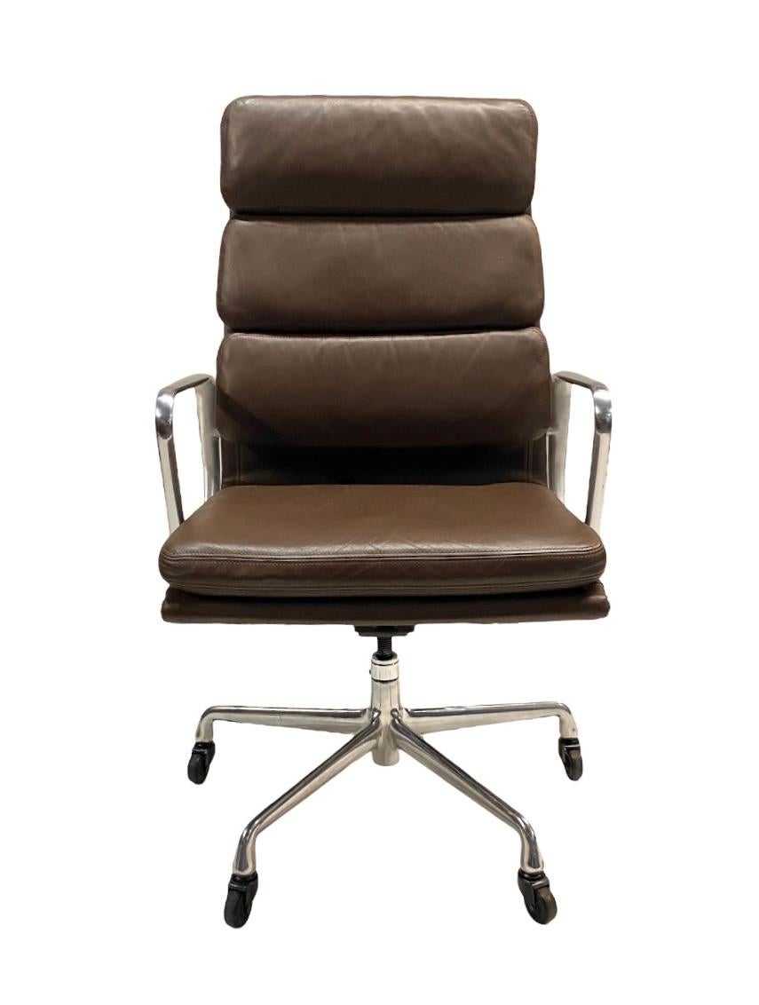 This is a very clean example of the iconic Eames soft pad chair. Executive model executed in supple brown leather and polished aluminum frame, base, and arms. Features adjustable height, adjustable tilting mechanism, and swiveling base with casters.
