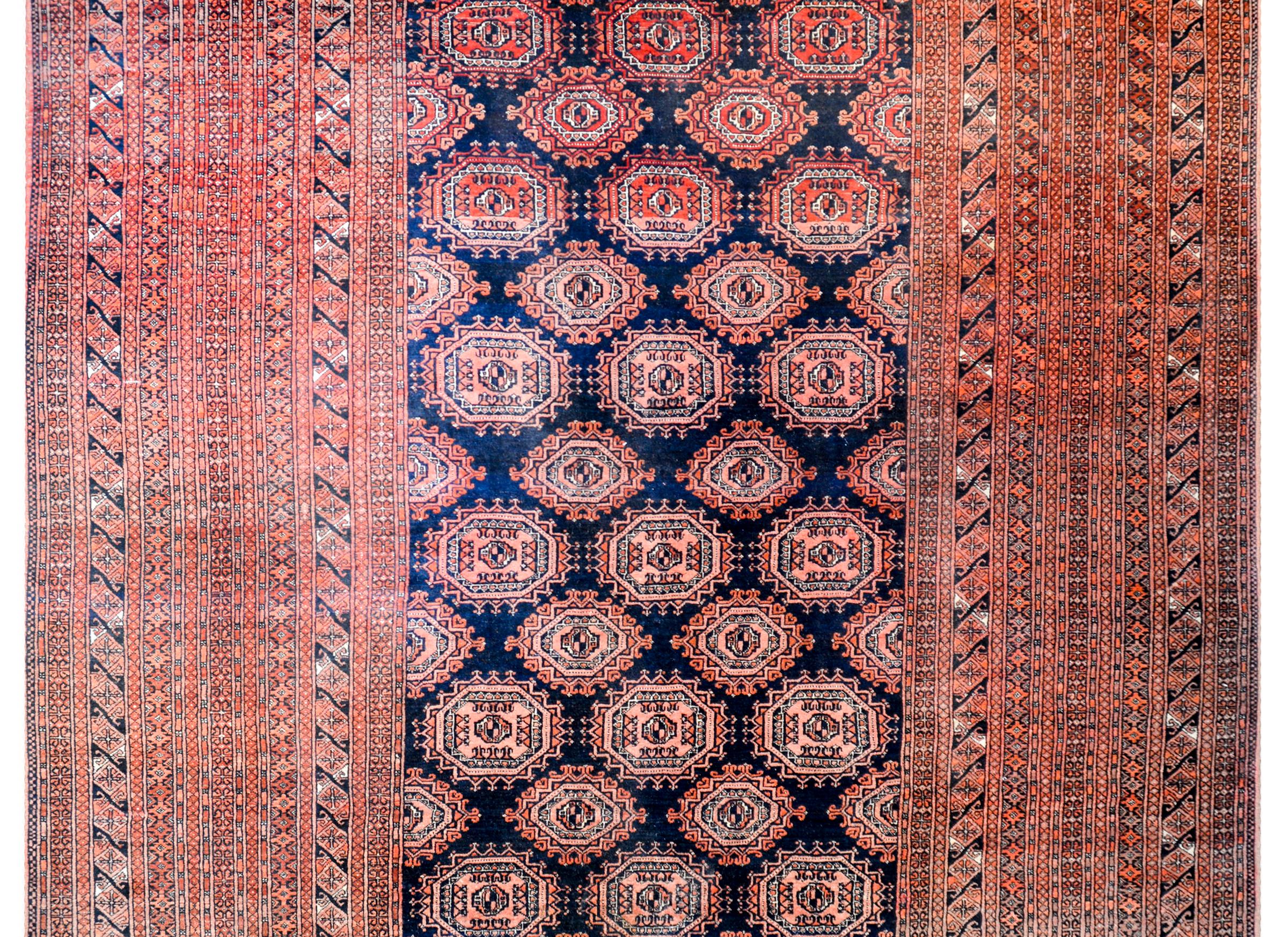 A gorgeous early 20th century Afghani Bashir rug with an elaborately woven field of stylized geometric flowers. The border is unbelievable, occupying about 60% of the overall rug design. Myriad thin stripes, each containing a petite geometric or
