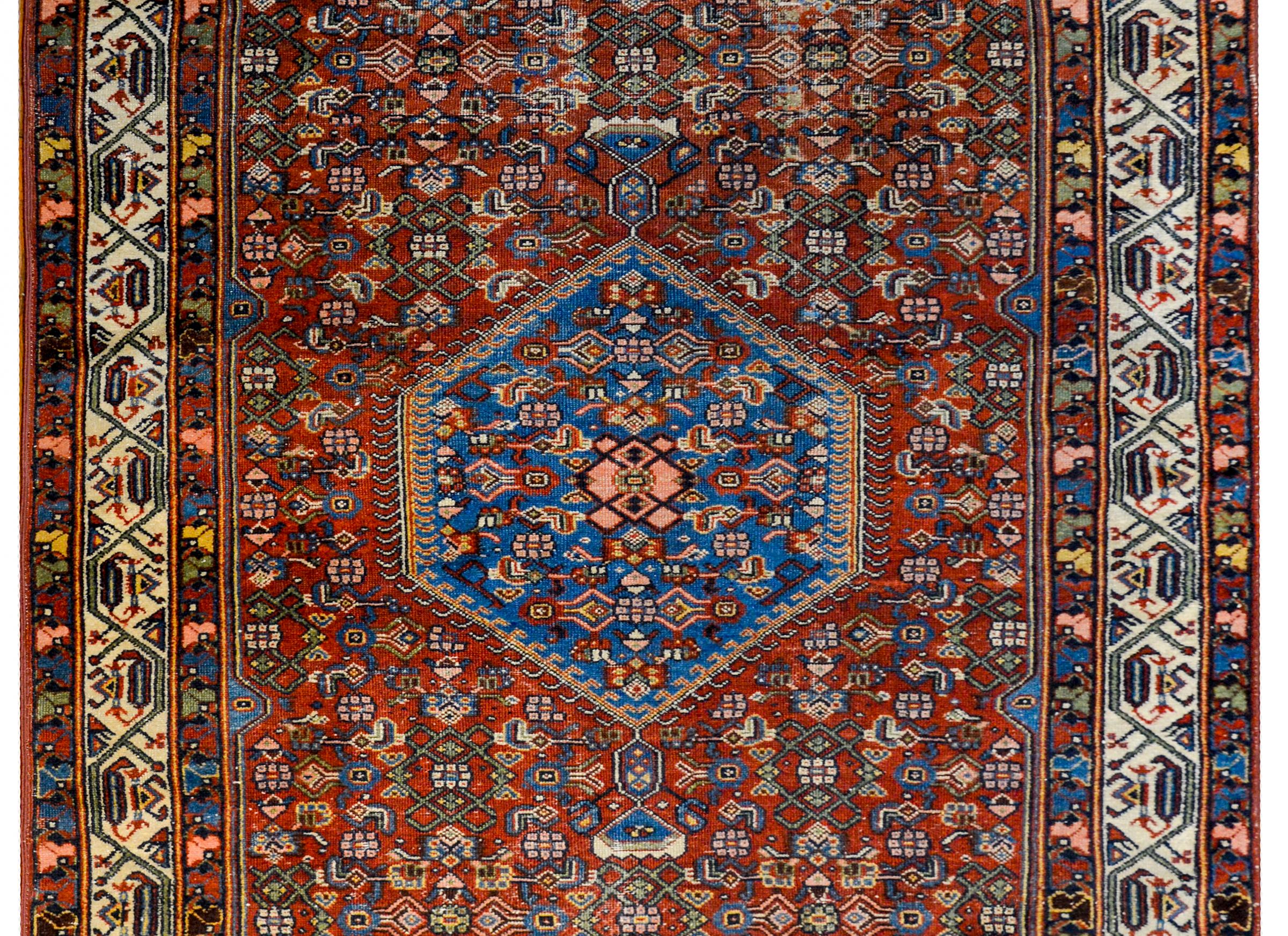 A gorgeous early 20th century Persian Bidjar Herati rug with an incredible central diamond medallion with a floral and leaf trellis pattern on an indigo background. The medallion lives amidst a field of similarly patterned floral and leaf trellis