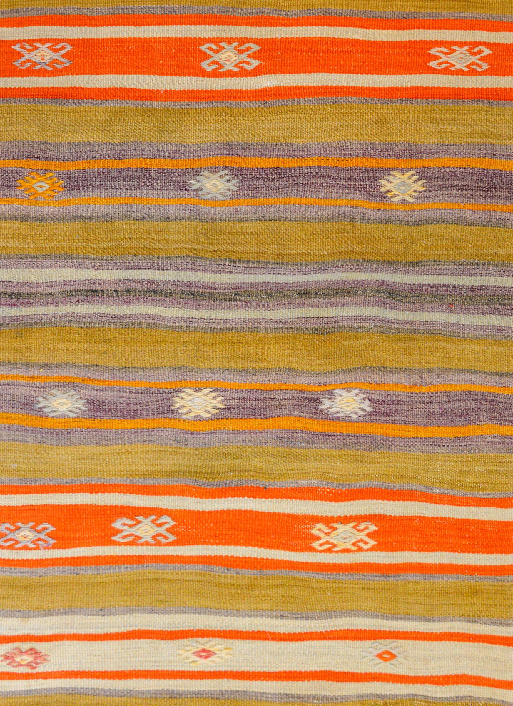 A gorgeous early 20th century Turkish Konya Kilim runner with a wonderful striped pattern woven in beautiful greens, oranges, golds, and lavenders, embellished with embroidered stylized flowers.