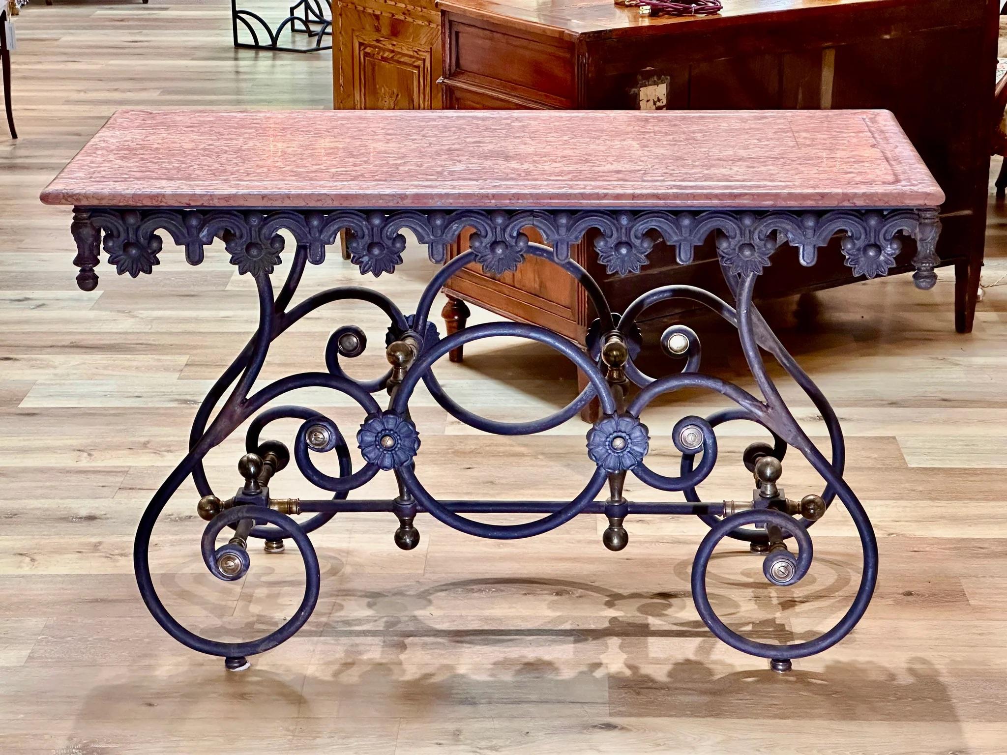 French late 19th-early 20th Century Pastry Table of narrow proportions.  The lovely LanguedocCaunes pink marble top over a wrought iron base having brass fittings.  The Table is narrower than is typical, measuring 31