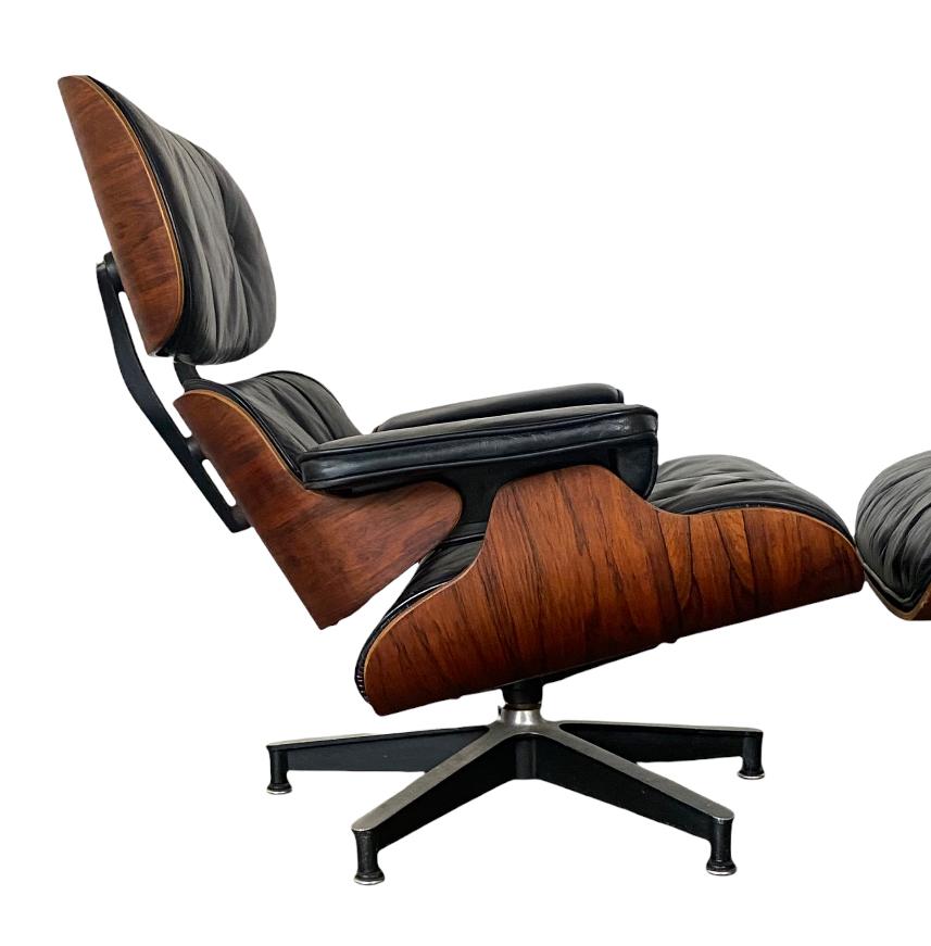Handsome example of the classic Eames lounge chair and ottoman. Circa late 1950s / early 1960s with down / feather cushions, black leather upholstery, and wooden shells upon cast aluminum bases. Signed and guaranteed authentic Herman Miller
