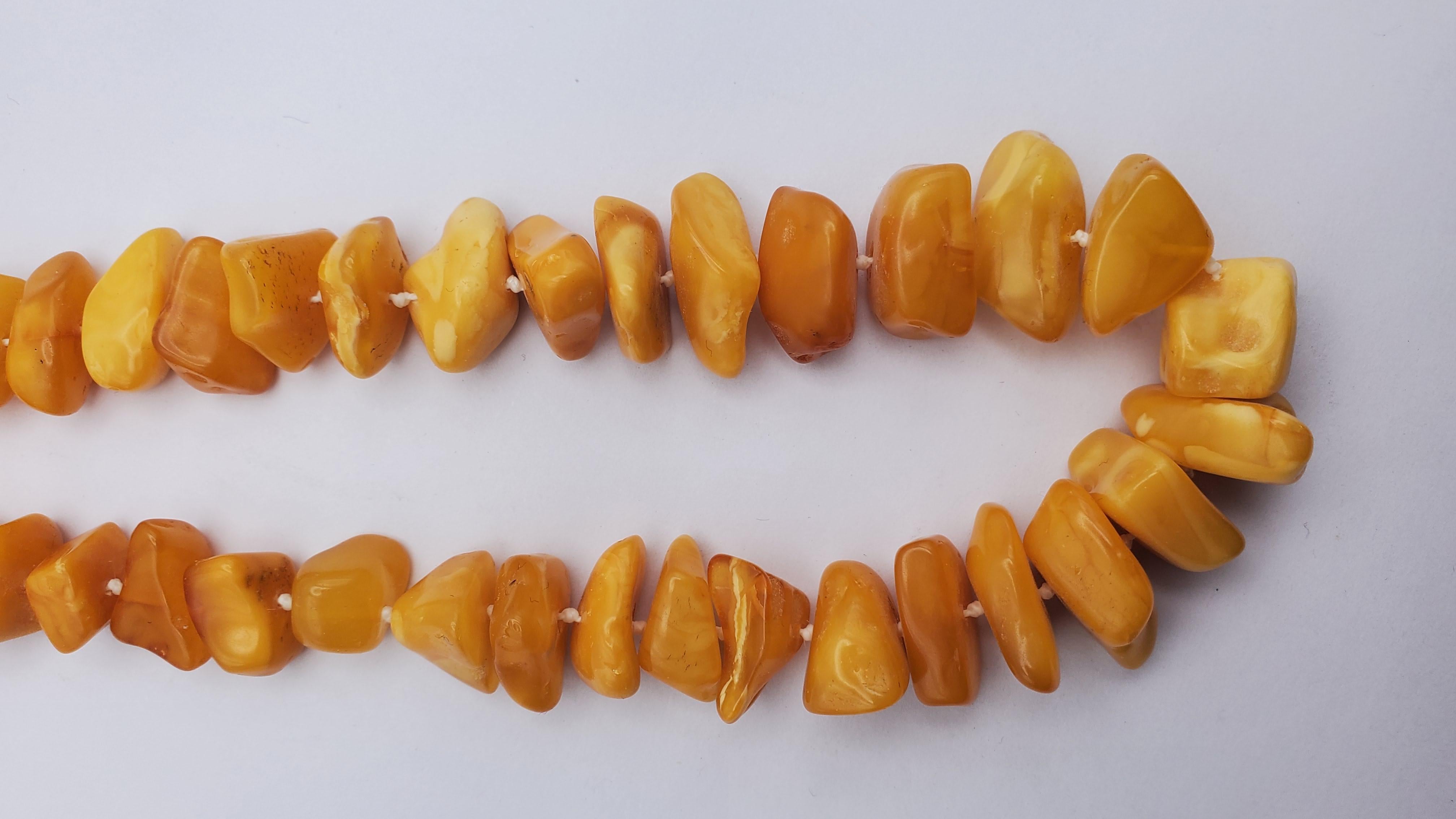 Gorgeous vintage Egg Yolk Baltic Amber bead necklace from the 1930s. The opaque warm golden colored beads are strung continuously with knots in a graduated design. The strand is 28 inches long to comfortably fit over the head. There are some natural