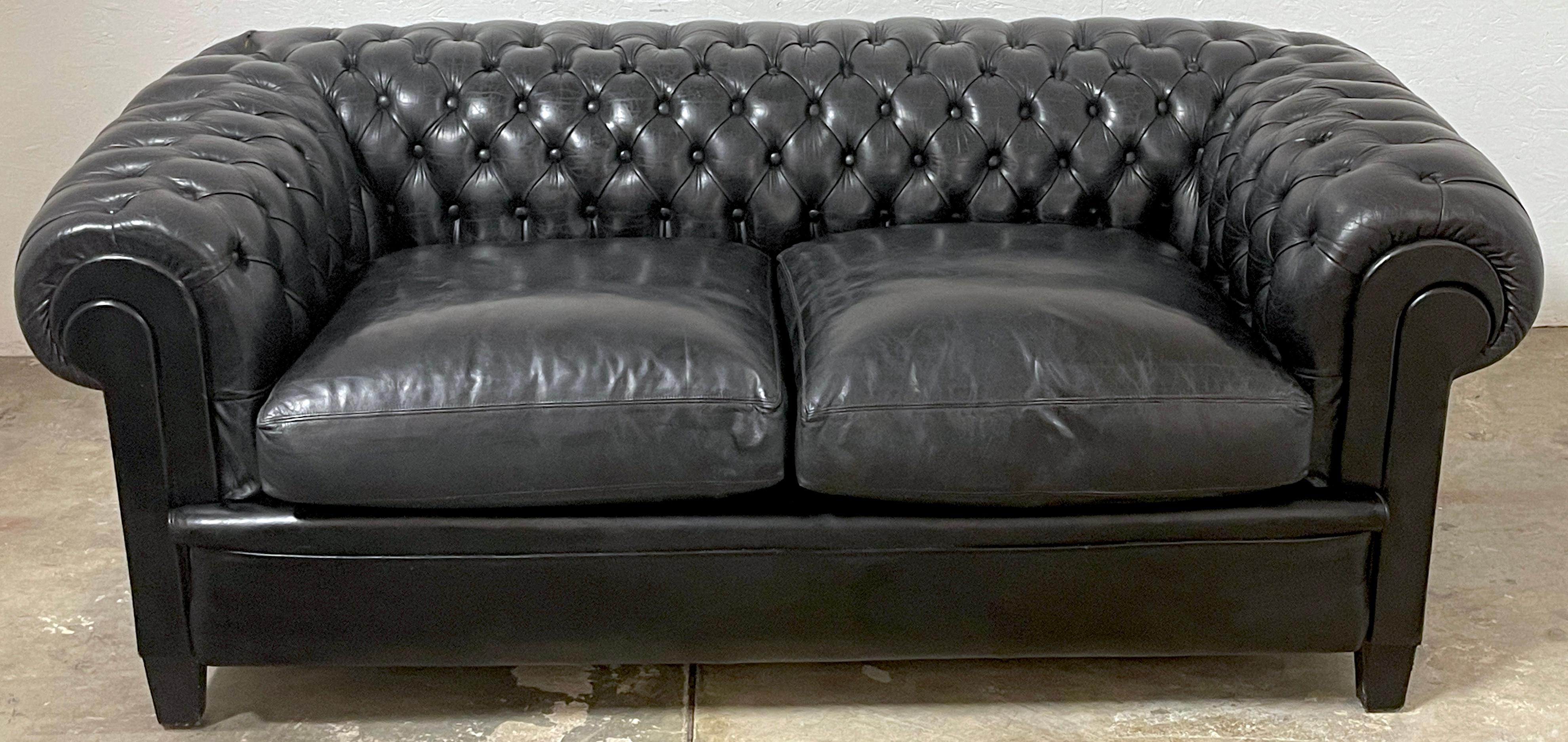 Gorgeous English Black Leather Chesterfield Sofa
England, 20th Century

This stunning 20th-century English Black Leather Chesterfield Sofa is a rare gem, boasting an uncommon midnight hue that exudes comfort. Its subtly distressed leather carries a