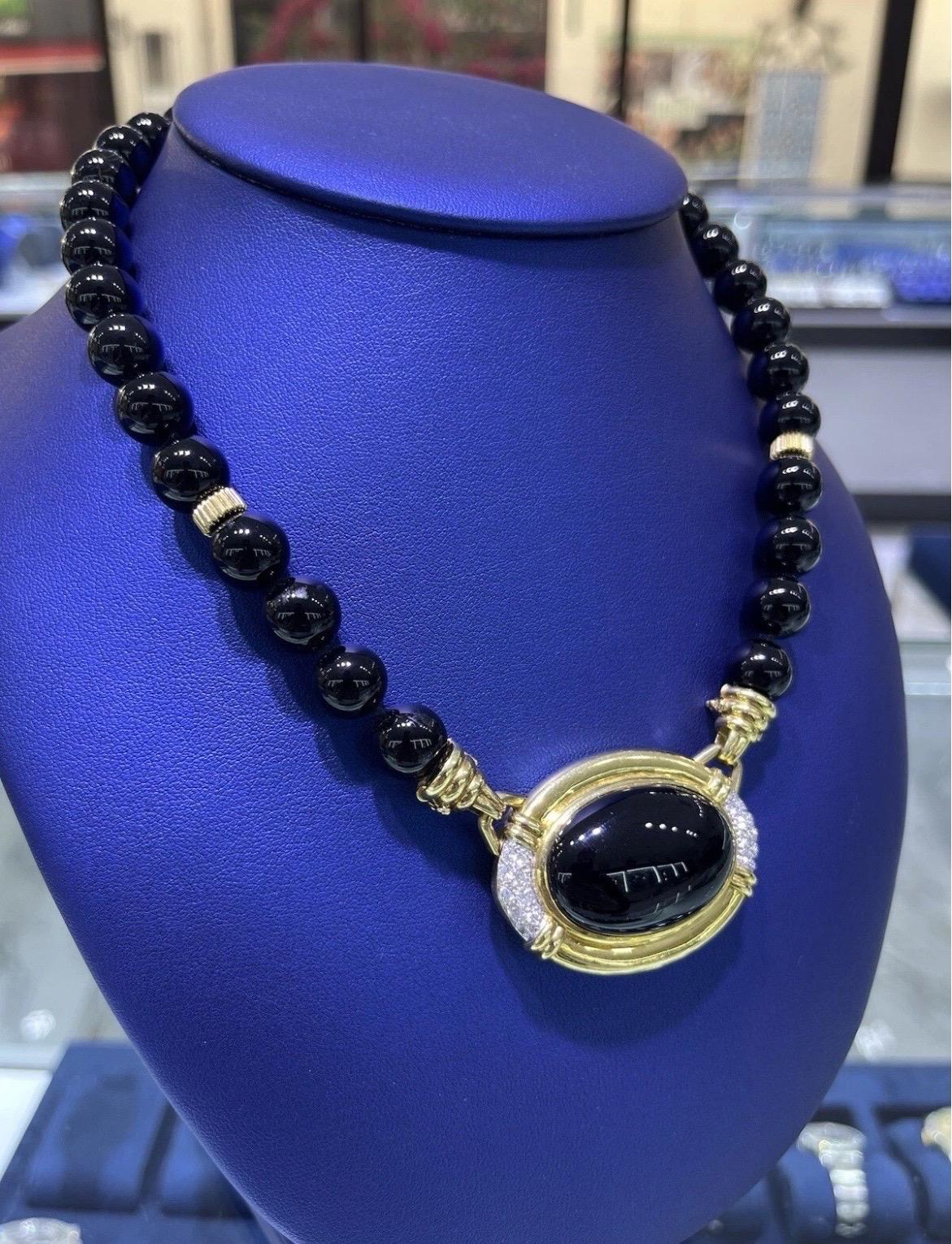 Ce collier exquis est composé de perles d'onyx noir rondes et polies, artistiquement enfilées et rehaussées de luxueux détails en or jaune 18 carats. La pièce maîtresse est un cabochon ovale d'onyx noir, encadré dans de l'or jaune 18kt nervuré et